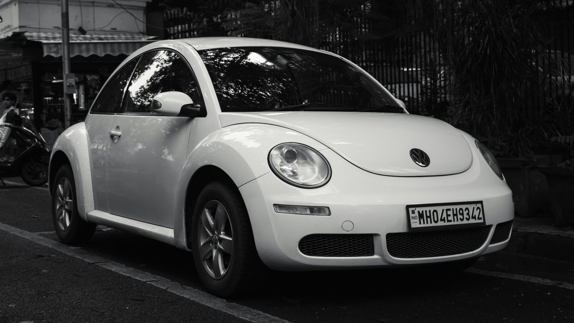 White volkswagen beetle parked on the side of road.