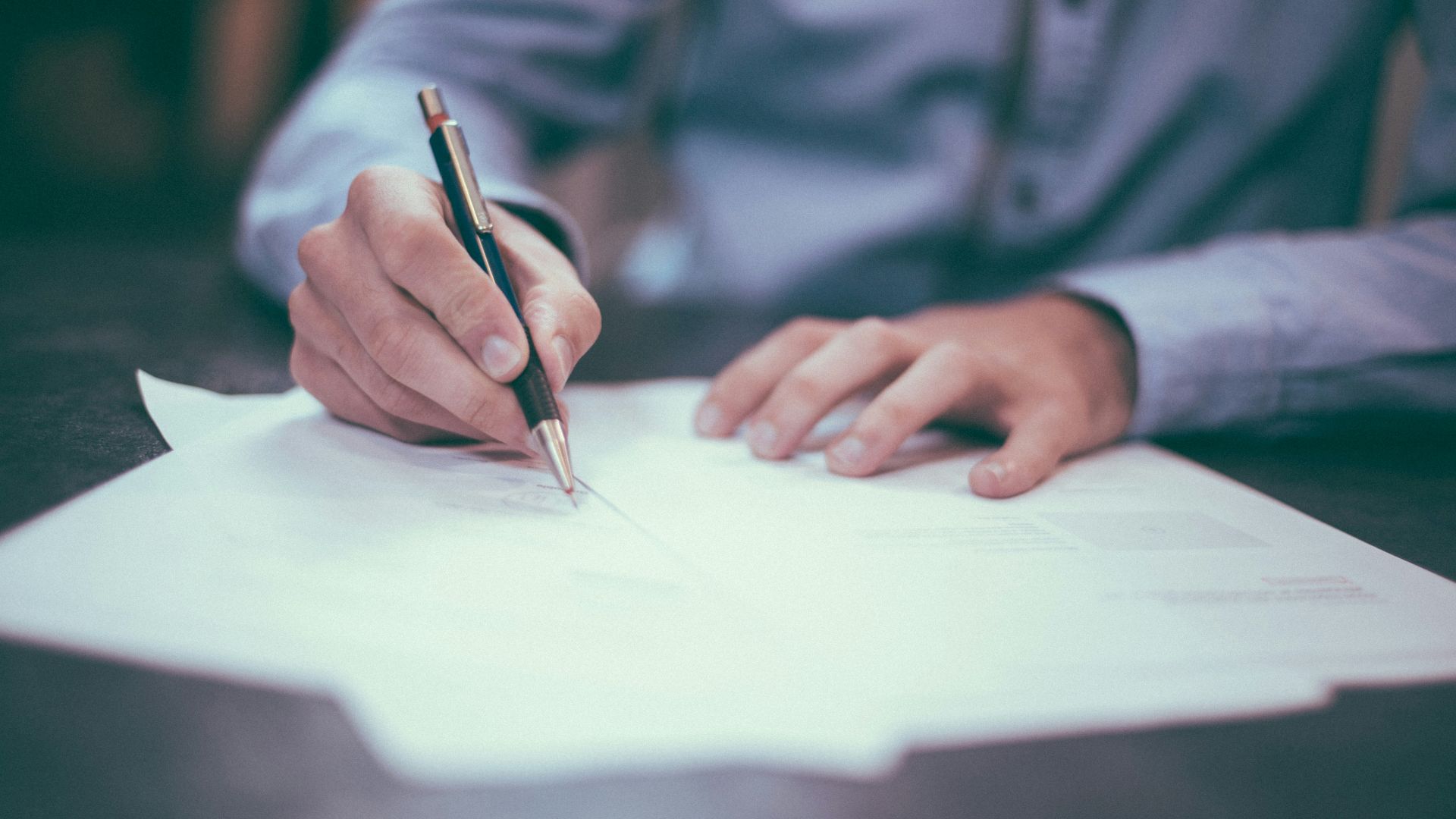 man writing on paper