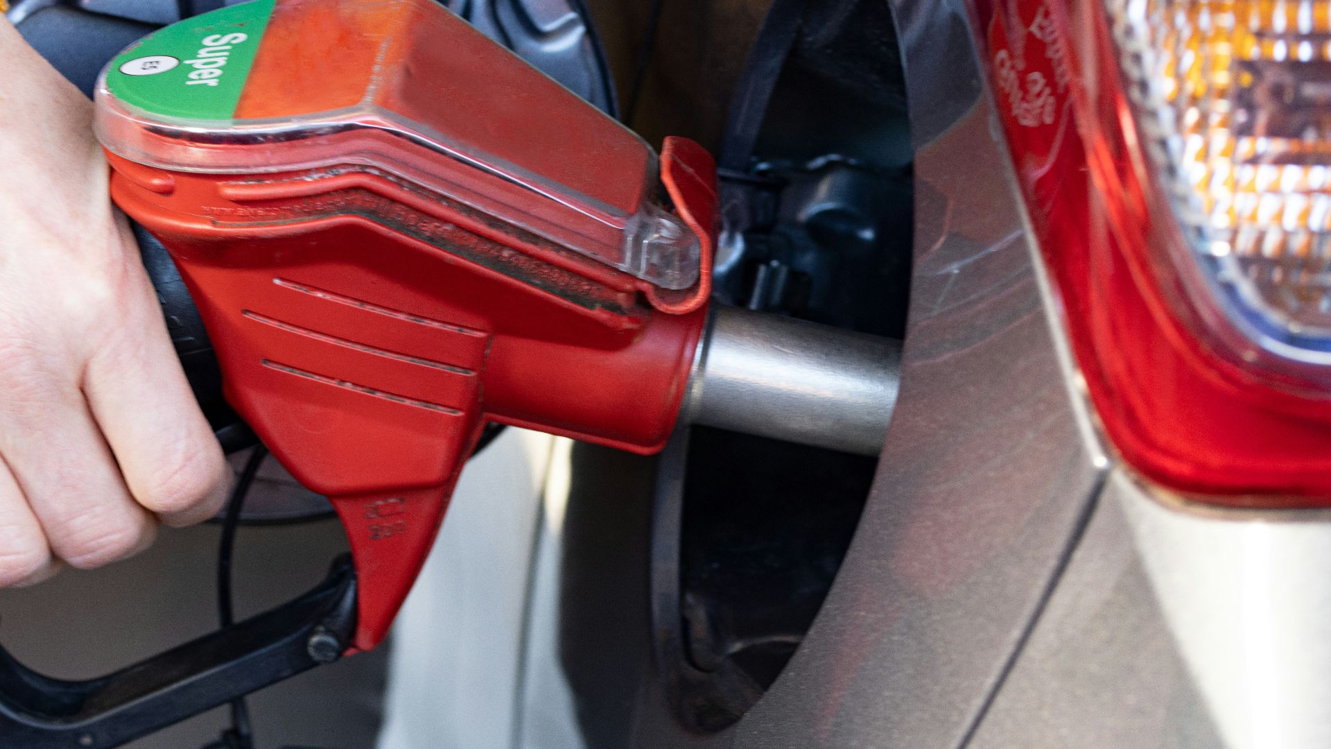 a person pumping gas into a car at a gas station