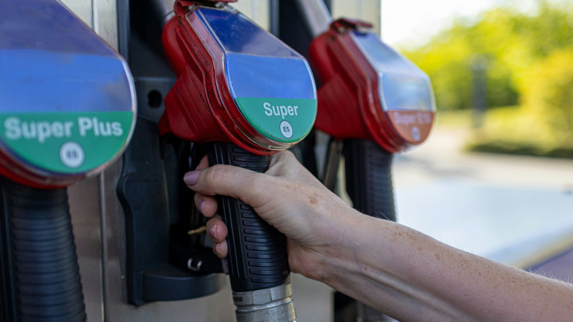 a person's hand is holding a gas pump