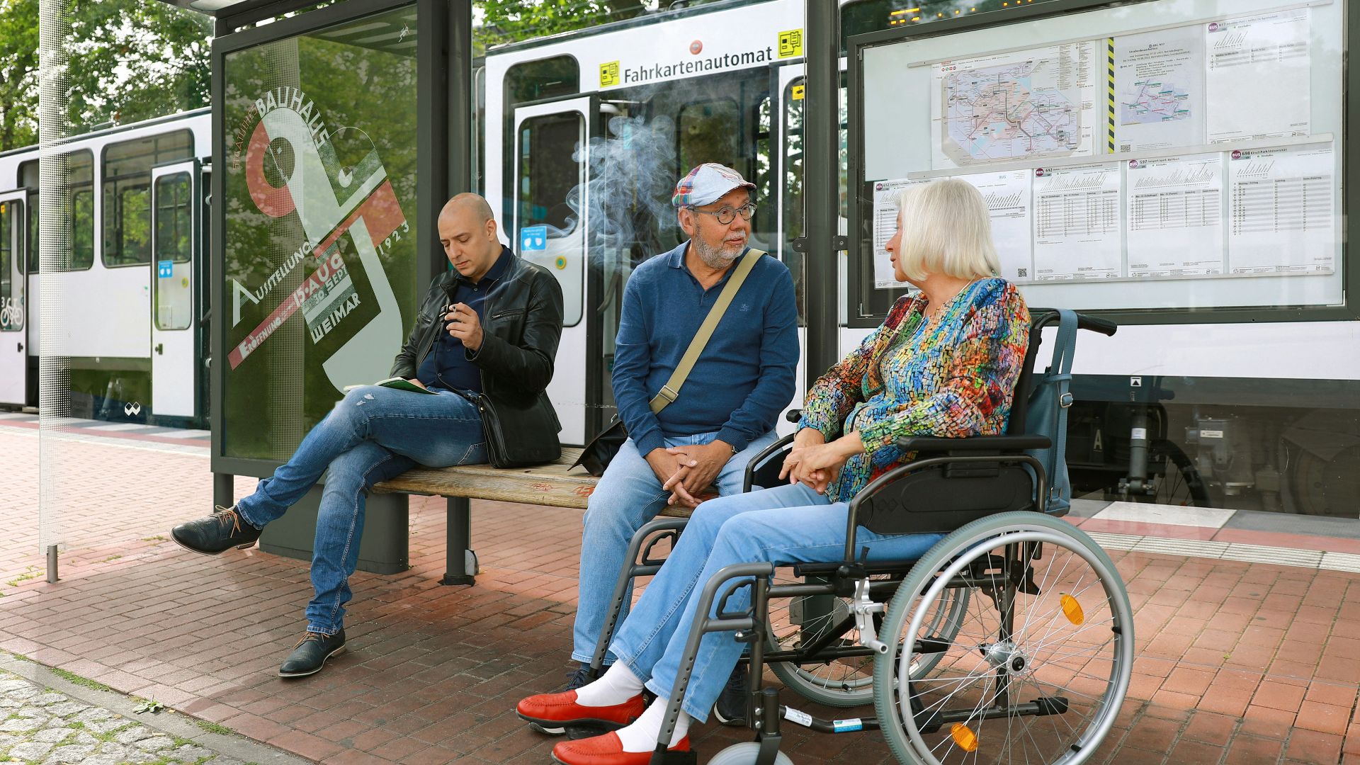 a group of people sitting on a bench next to a bus