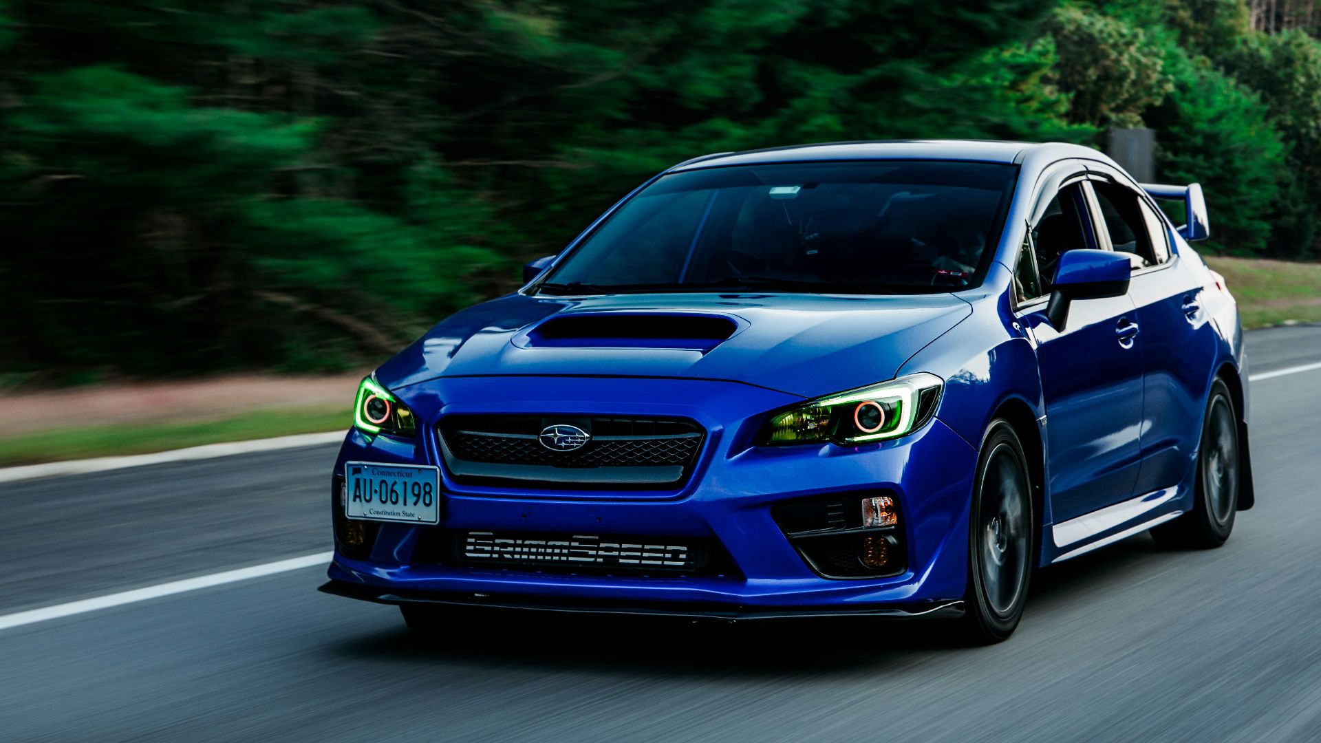a blue subarunt is driving down the road