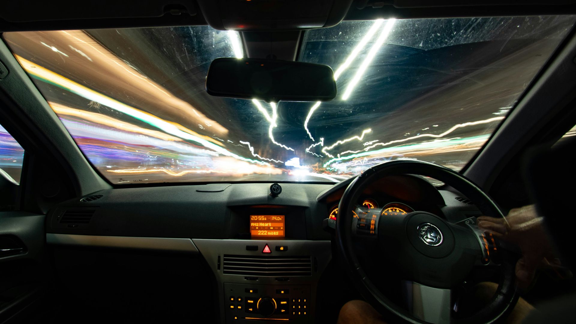 a car driving down a street at night