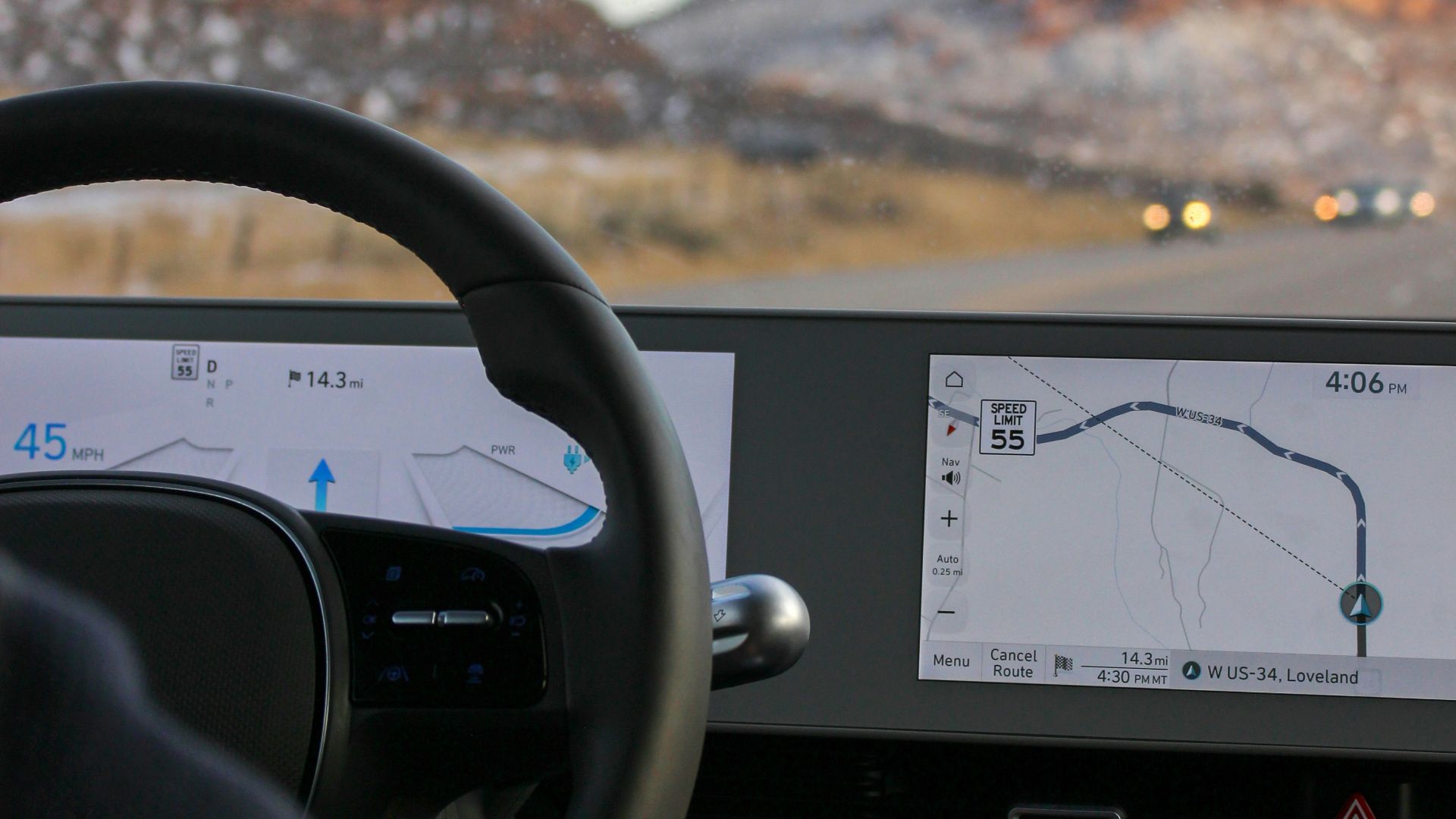 a man driving a car with a mountain in the background