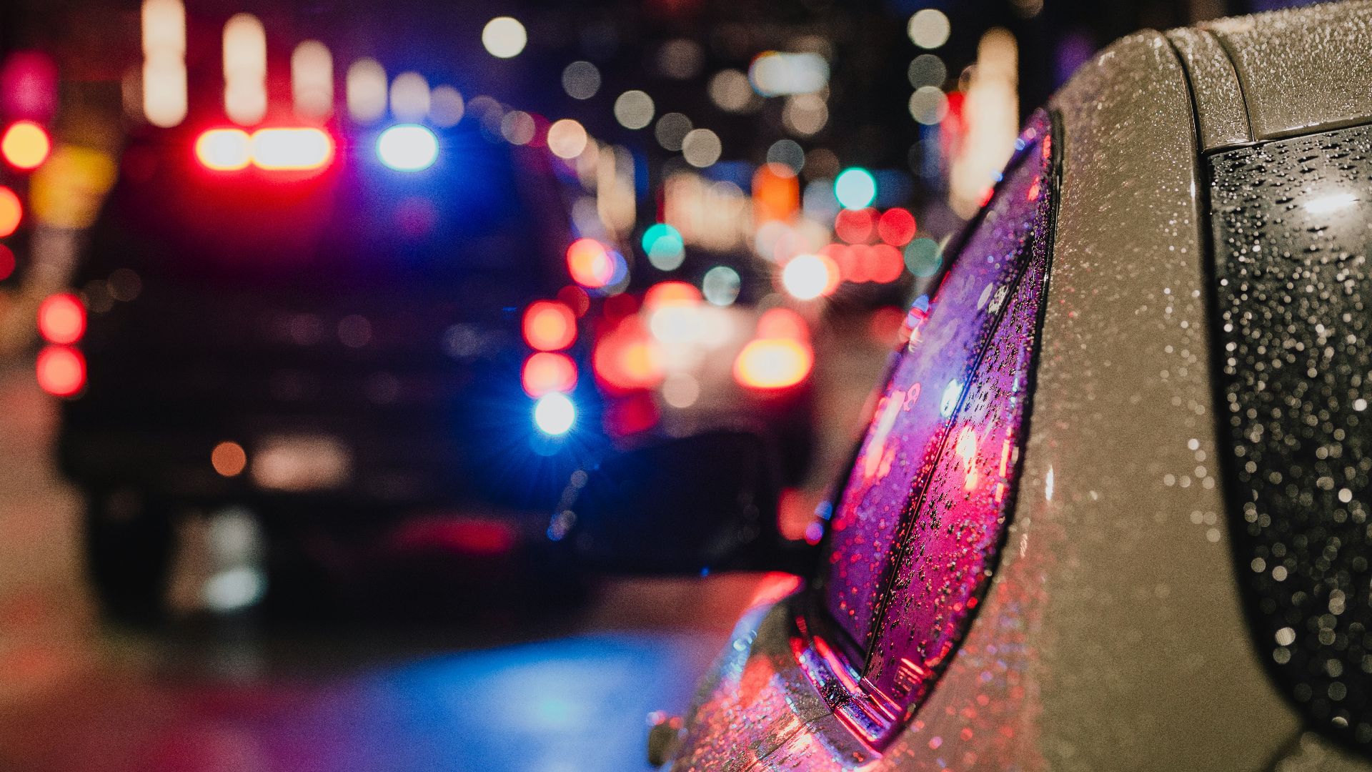 Police car with flashing lights on city street.
