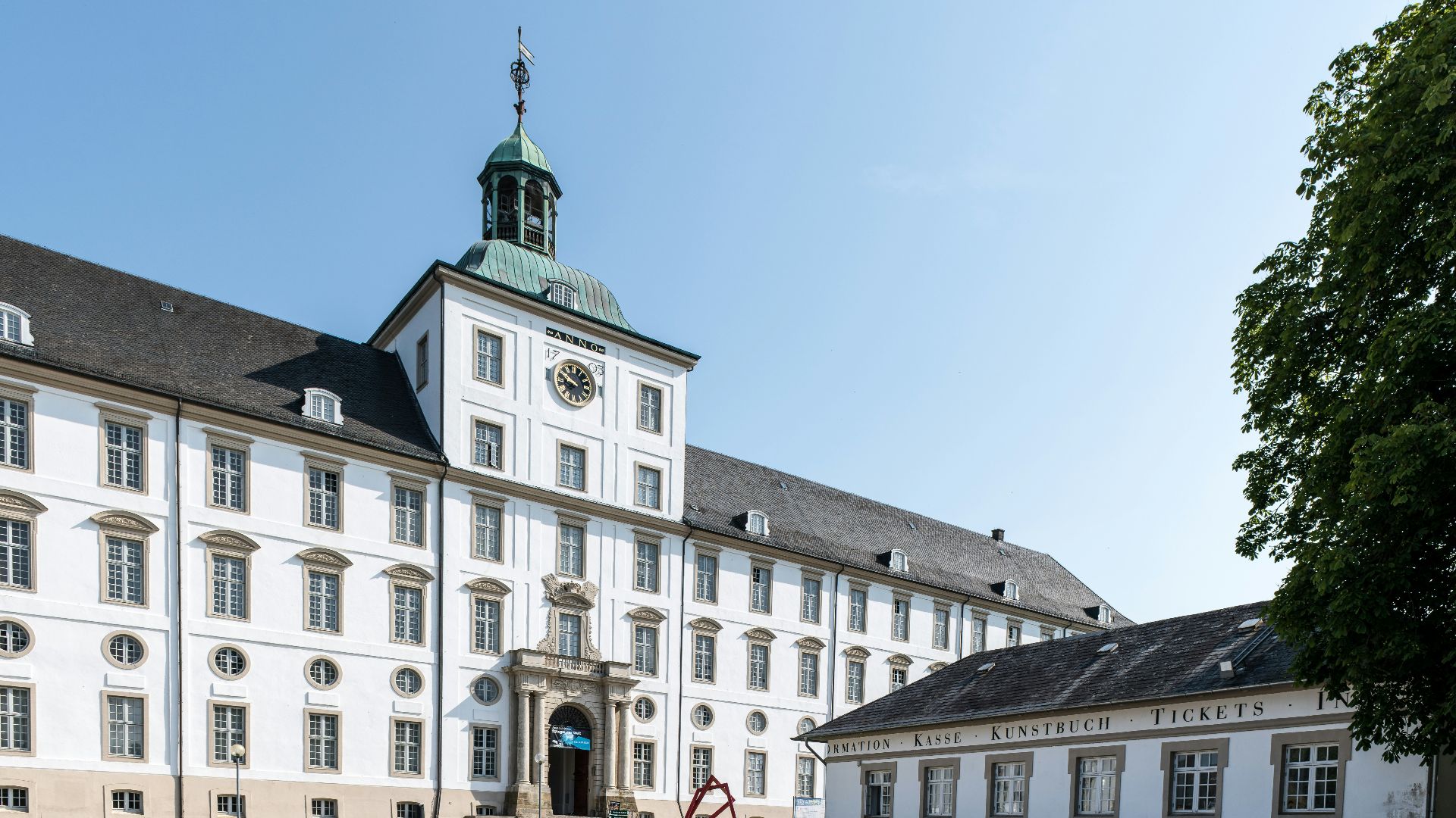 A large white building with cars parked in front of it