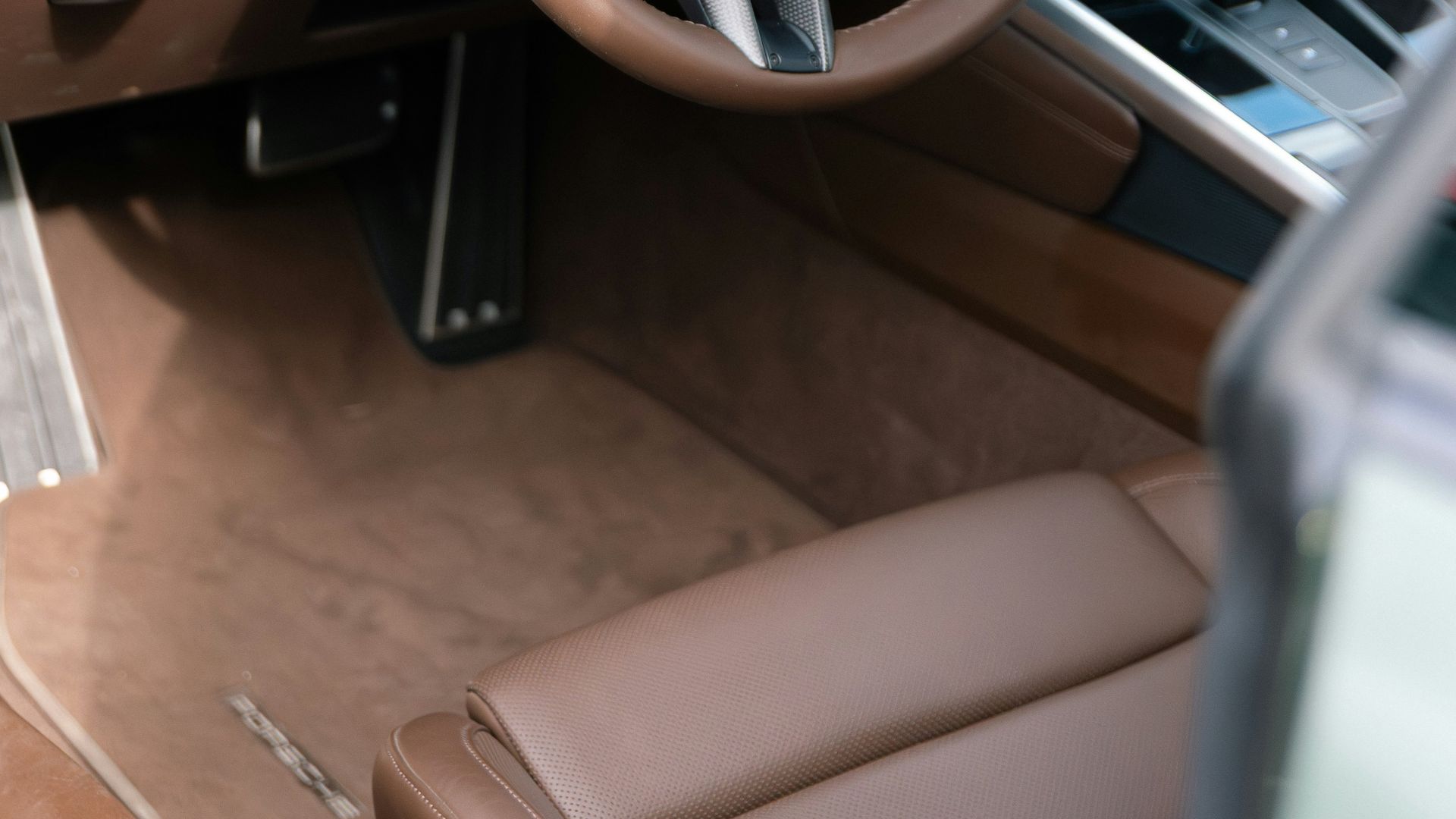 Interior view of a luxurious brown leather car dashboard.