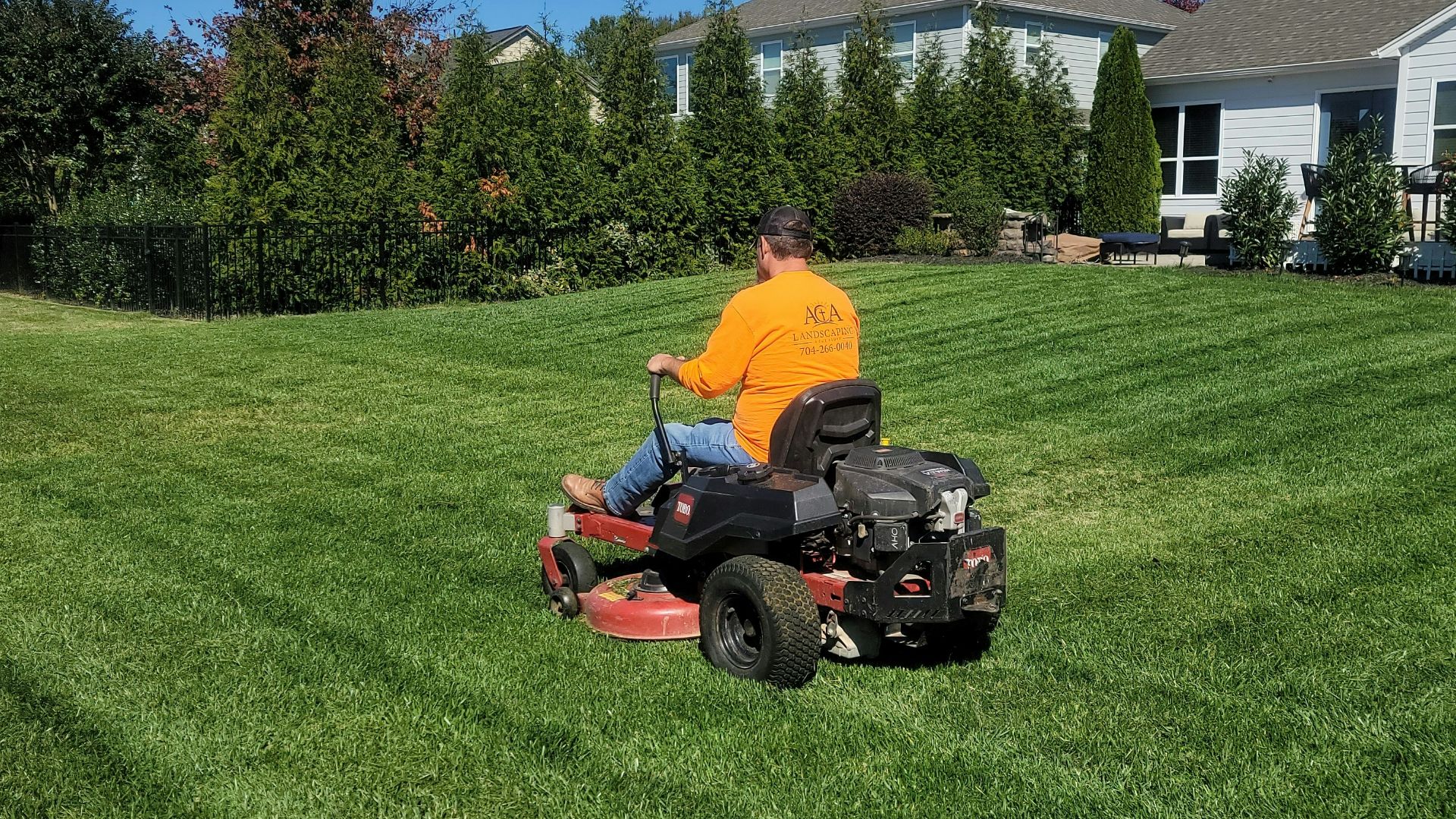 A man riding on the back of a lawn mower