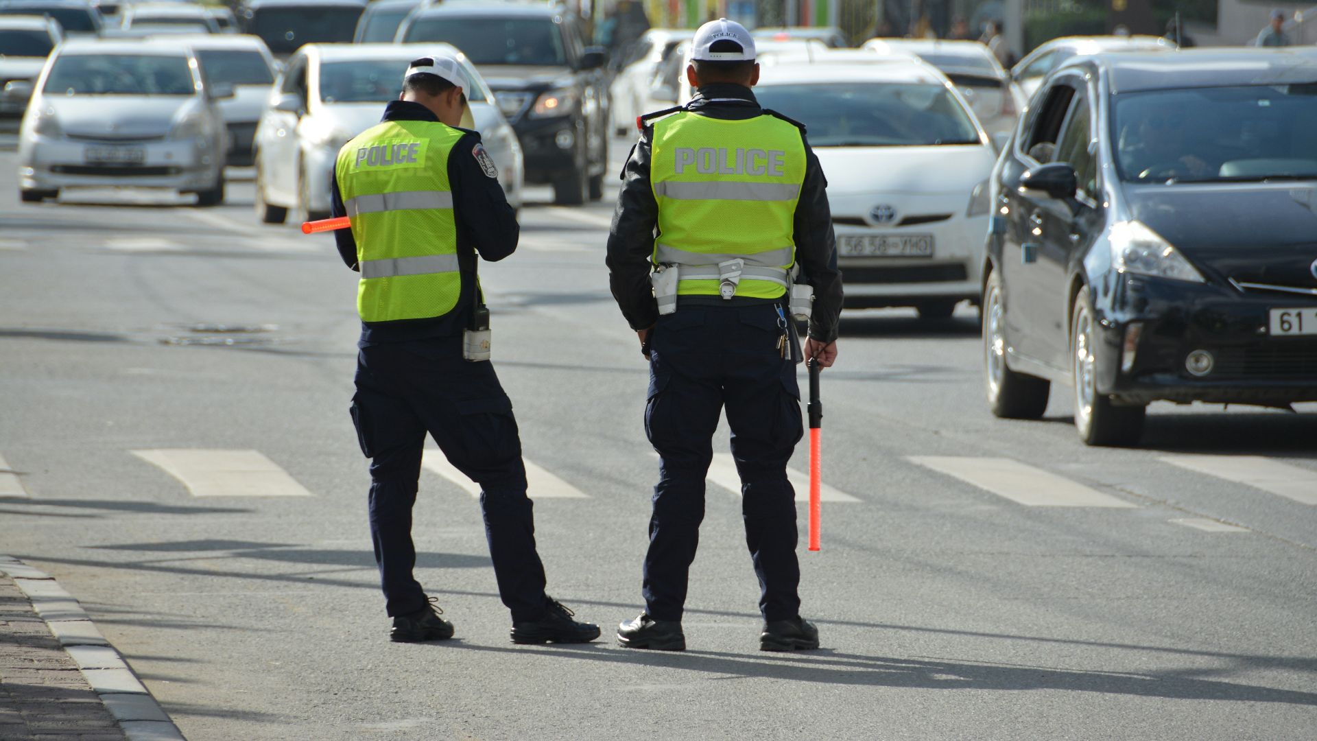two police officers standing on the side of a road
