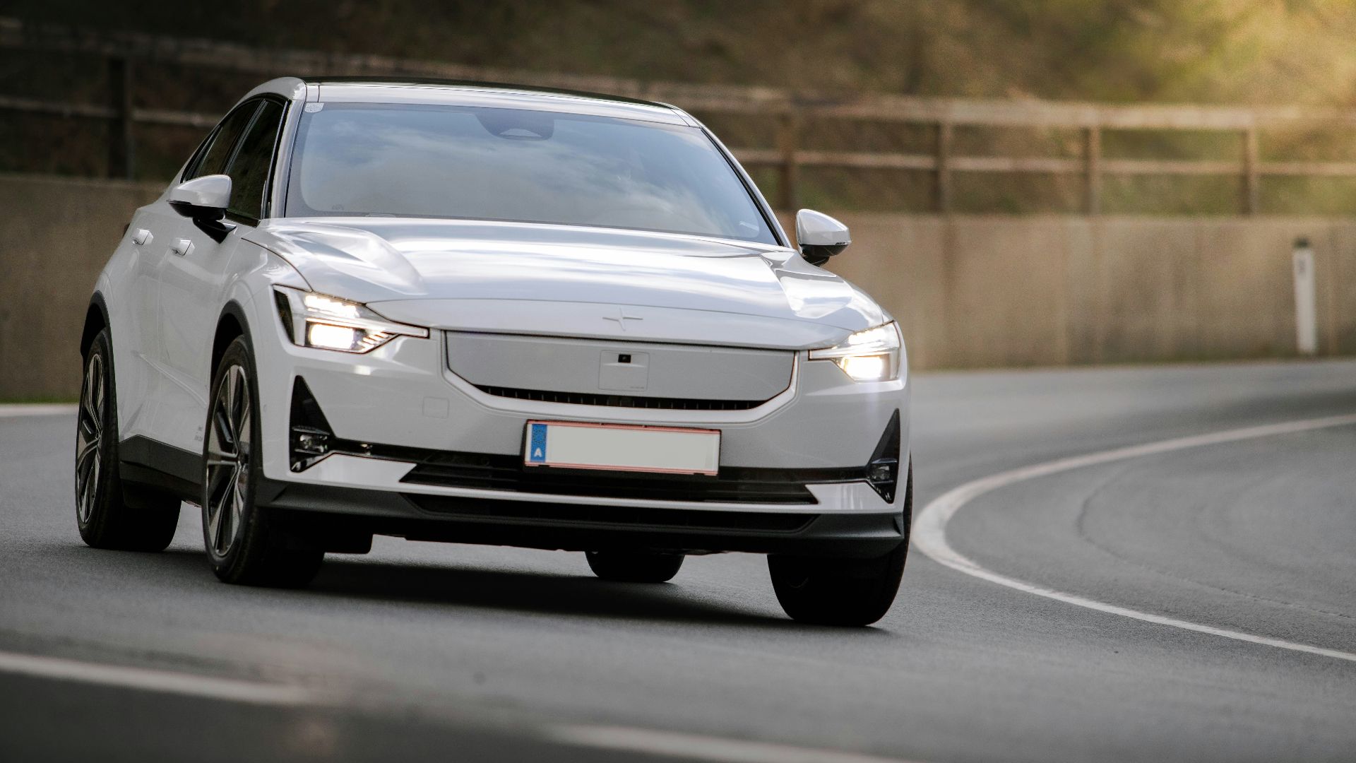 a white car driving down a curvy road