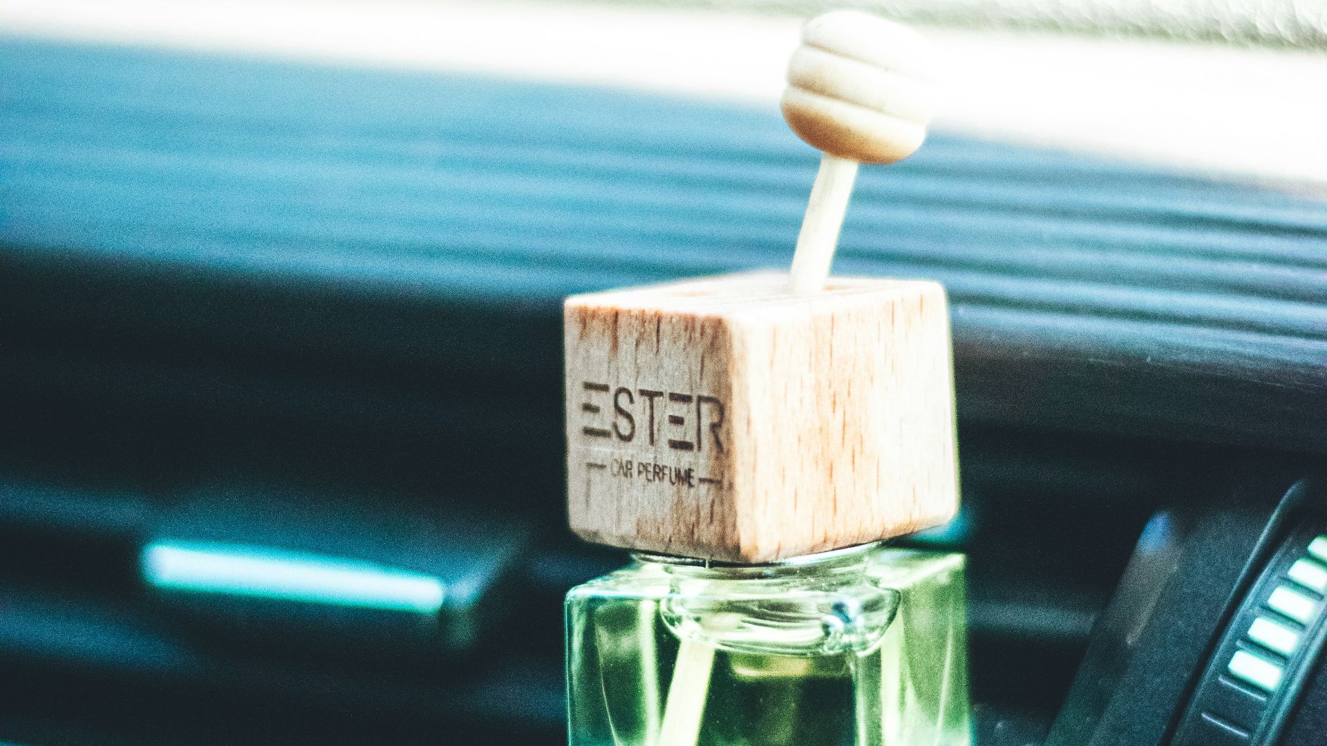 a small bottle of perfume sitting on the dash of a car