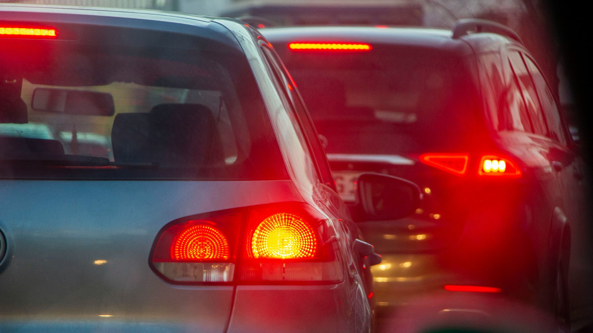 a group of cars driving down a street next to each other