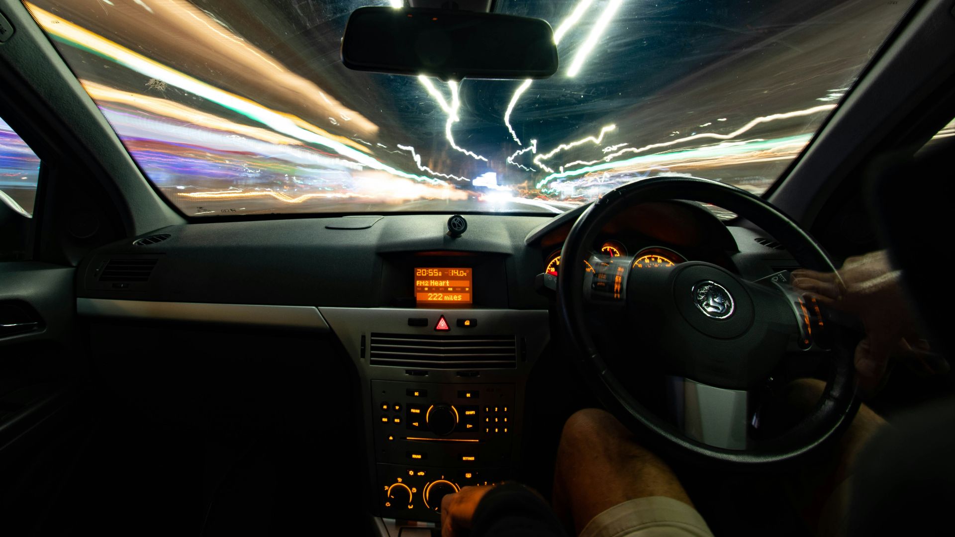 a car driving down a street at night