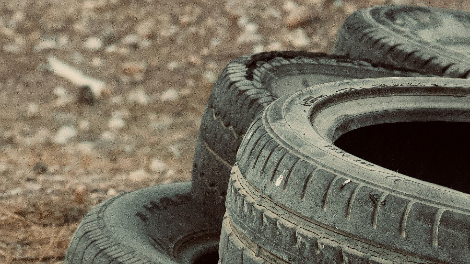 Stack of old tires on dry grass