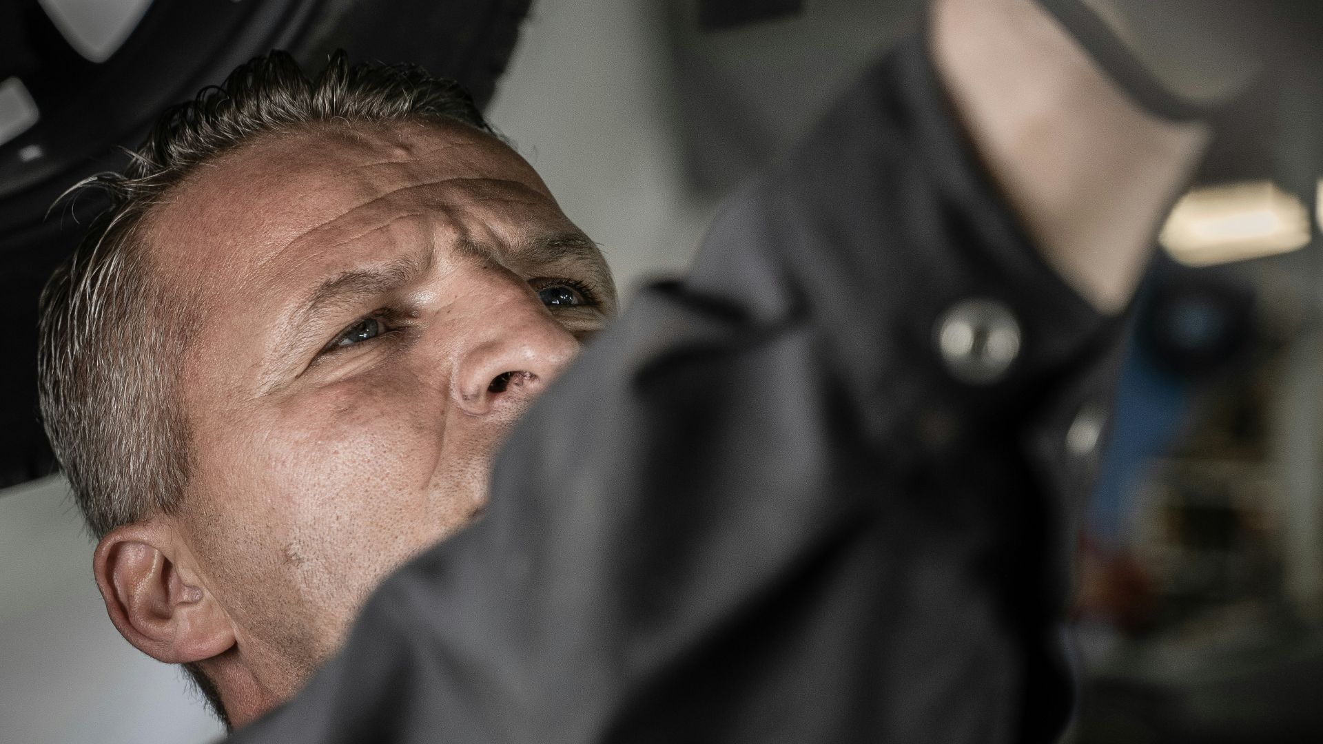 a man working on a car under a vehicle