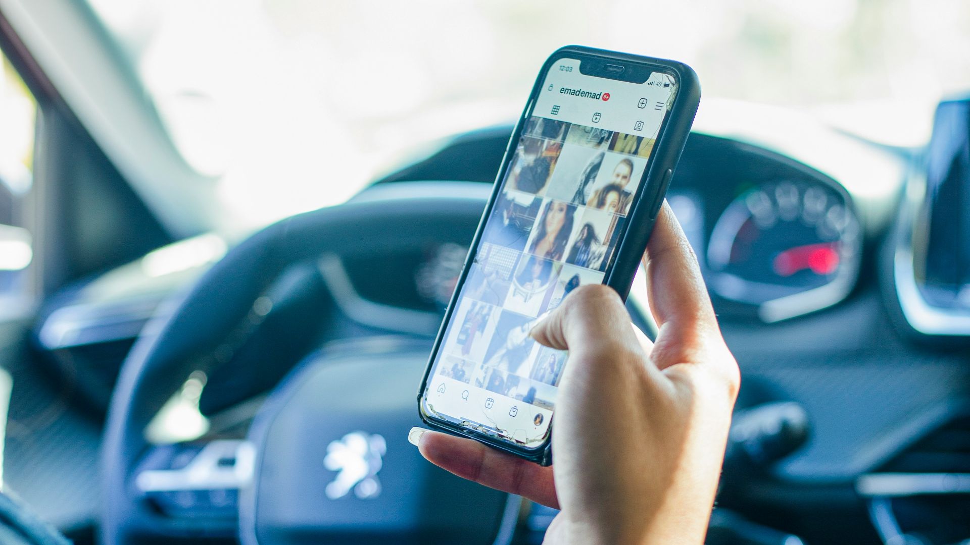 a person using a cell phone while driving a car
