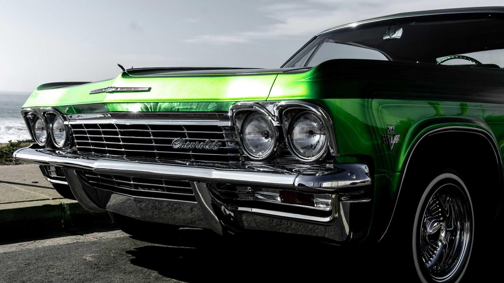 green car on gray asphalt road under gray sky