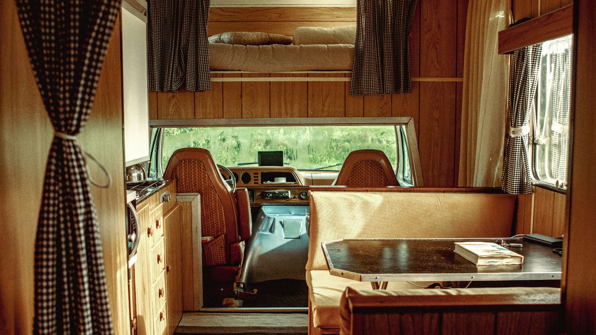 the inside of a camper with a desk and chairs