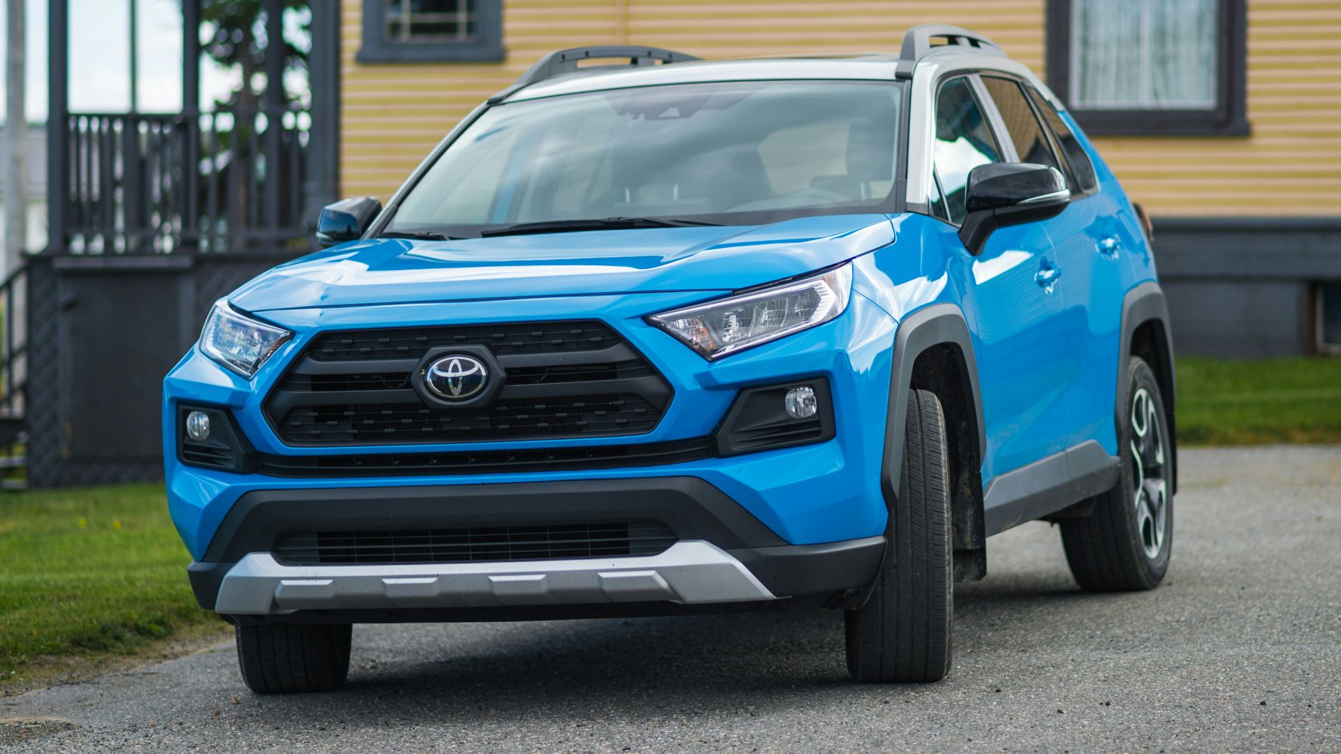 a blue toyota rav parked in front of a house