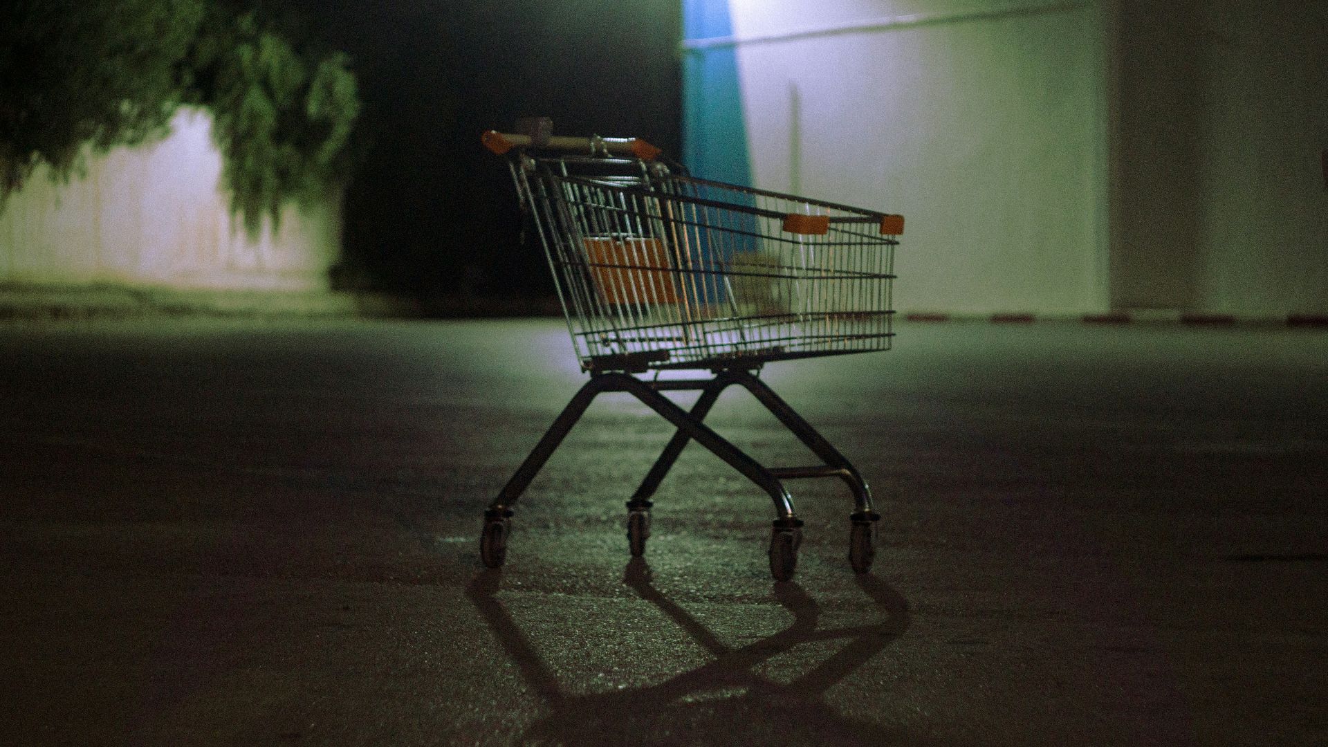 Shopping cart on wet pavement at night