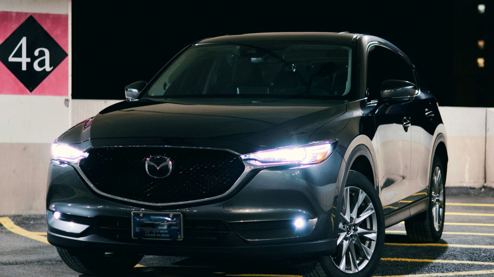 A black mazda suv is parked at night.