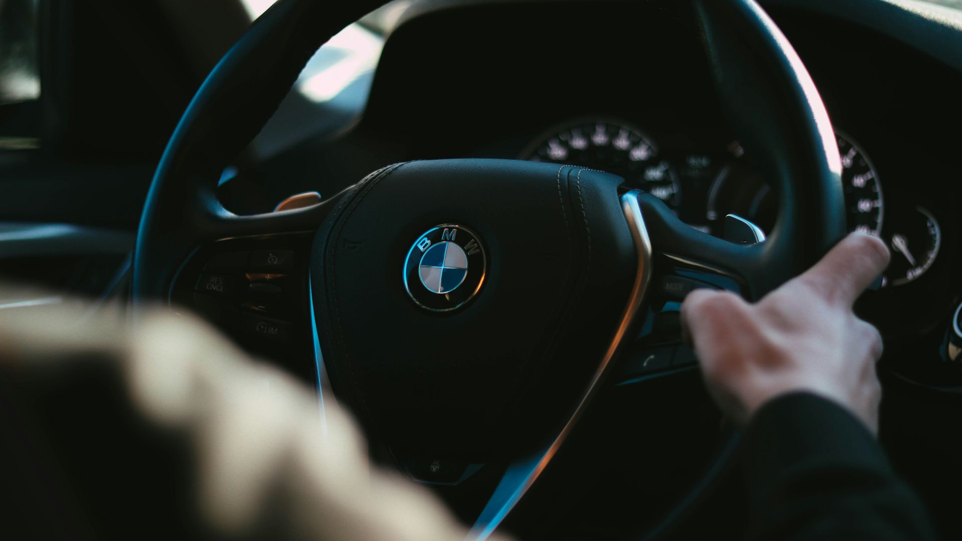 person holding black bmw steering wheel