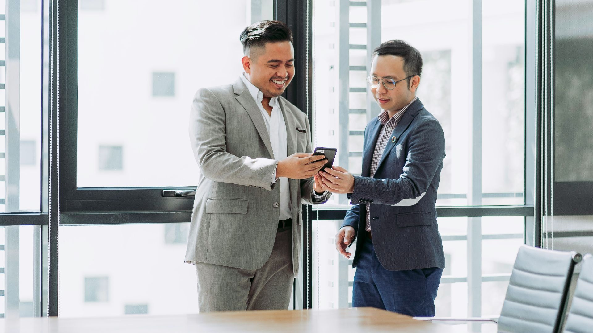 two men shaking hands in a conference room