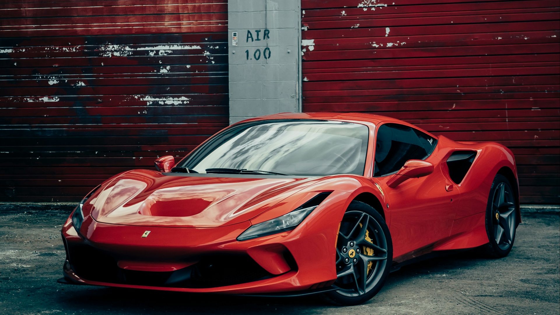 red ferrari 458 italia parked beside red wall