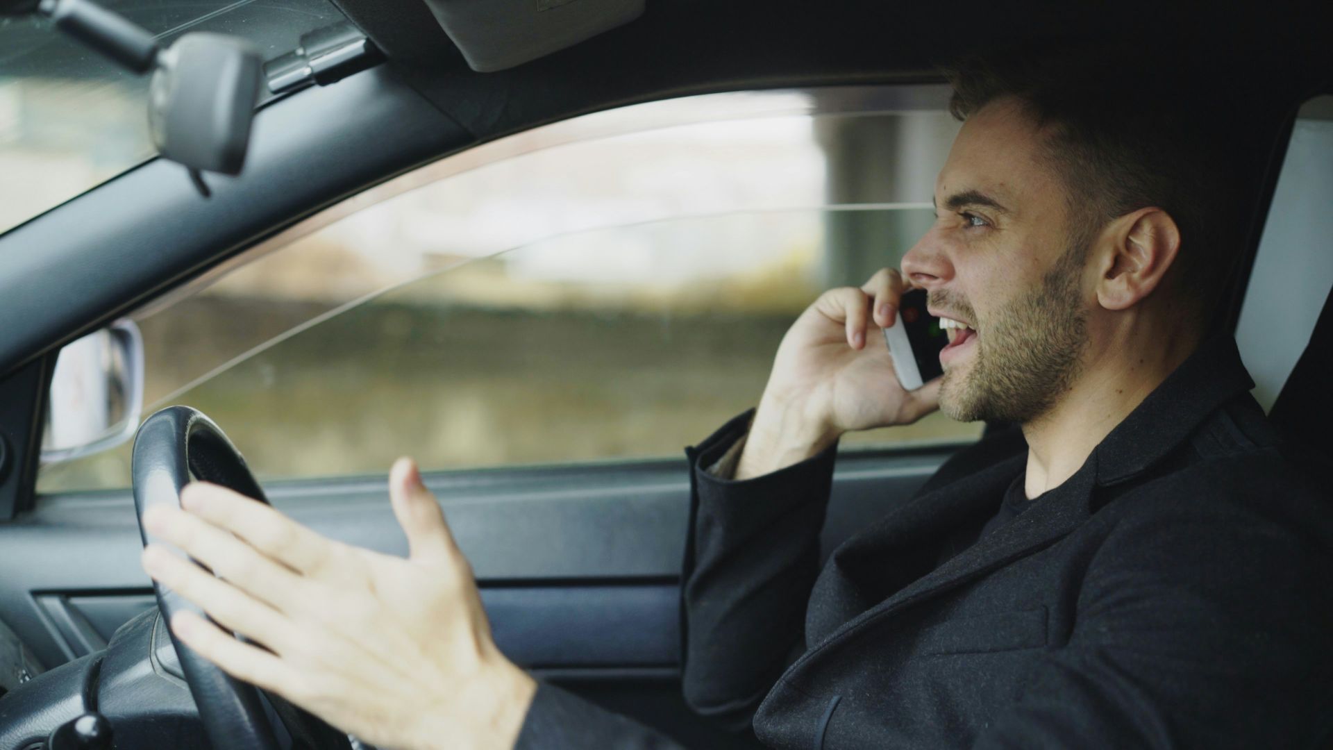 Man talking on phone while driving car