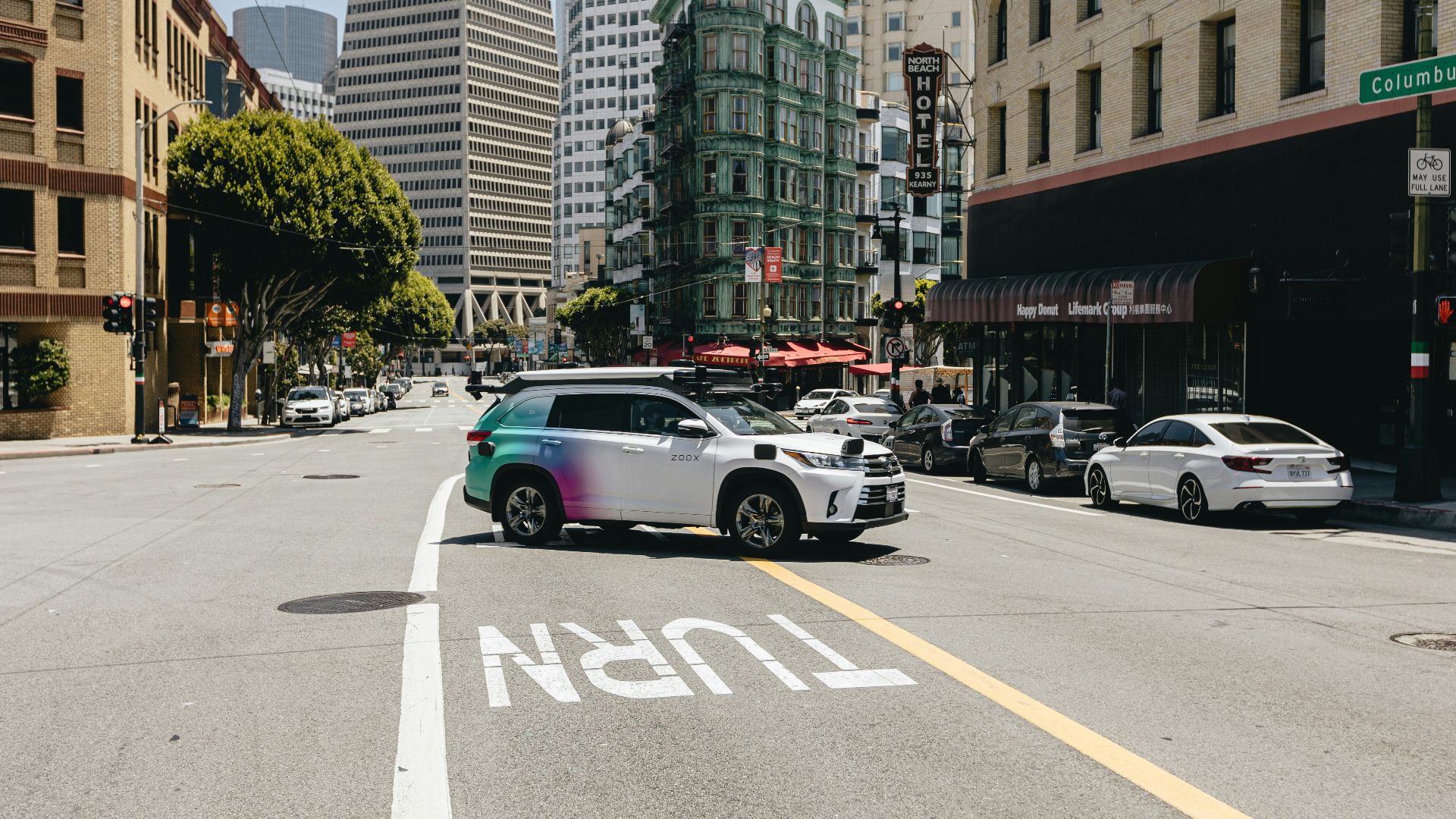 a car driving down a street next to tall buildings