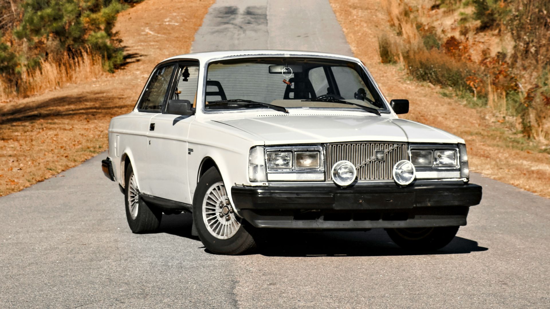 a white car parked on the side of a road