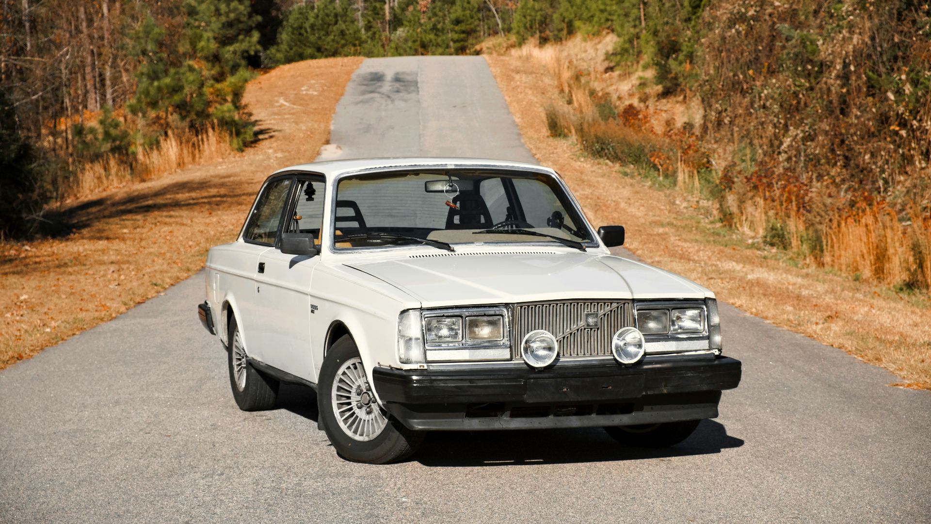 a white car parked on the side of a road