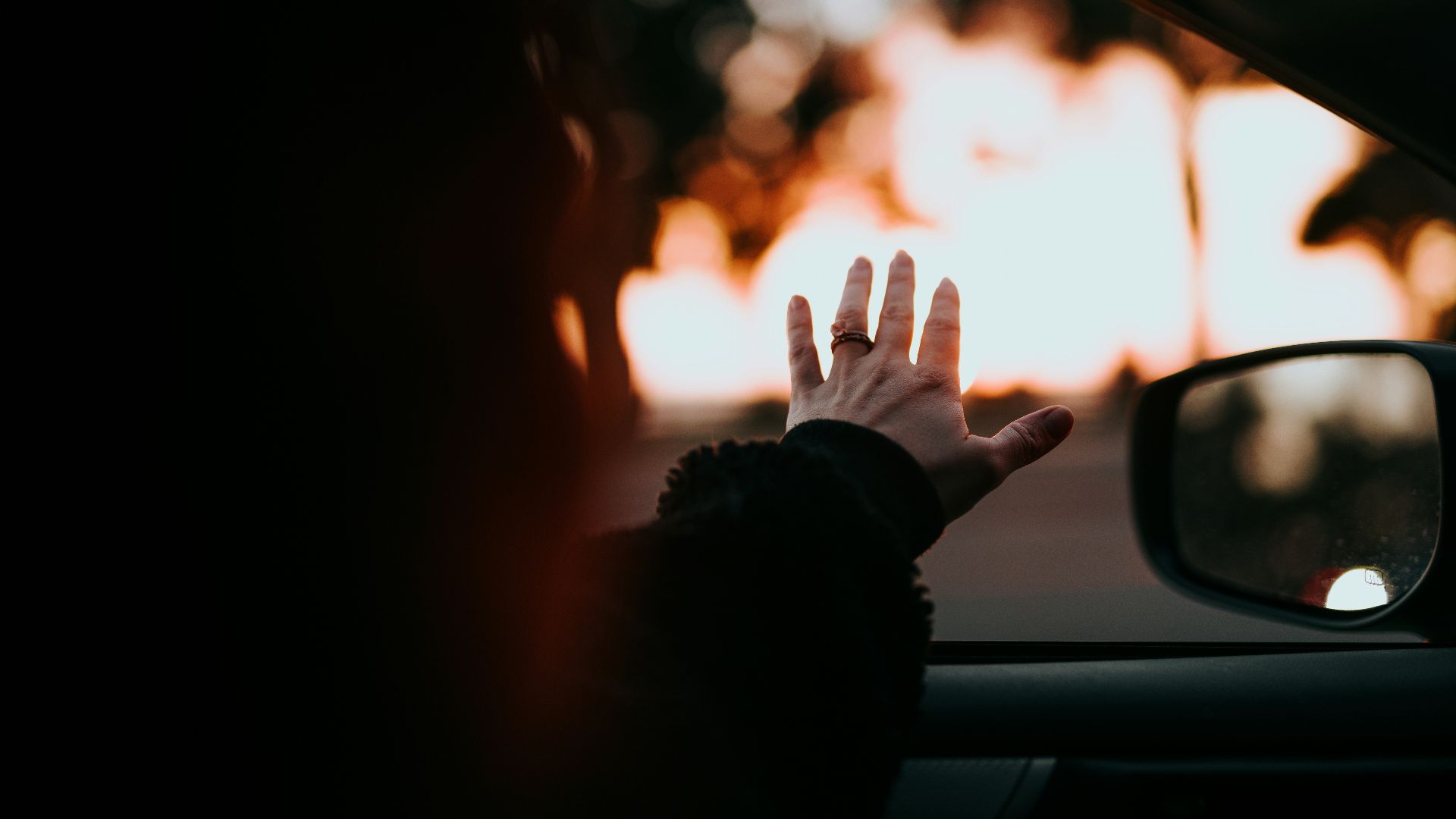 person in black long sleeve shirt raising hand