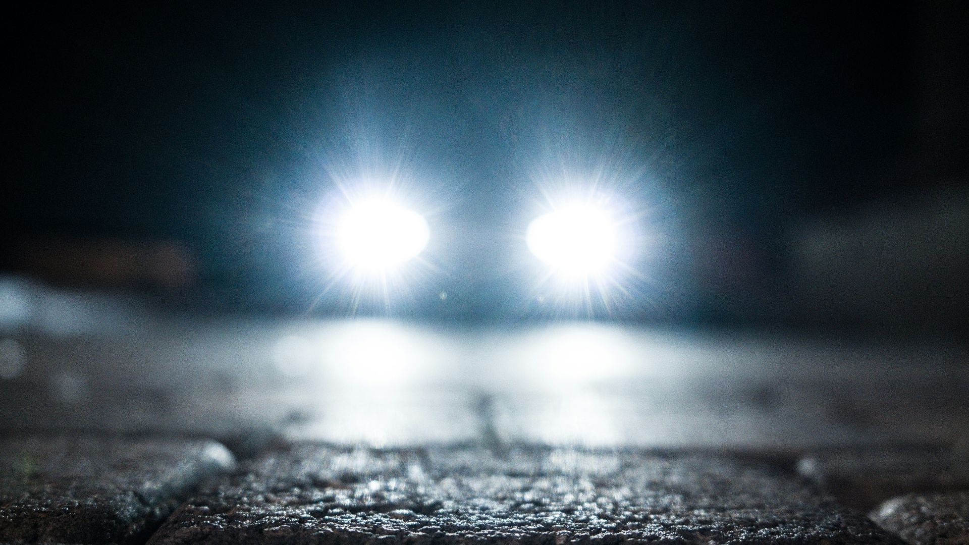 turned-on vehicle headlight on the street