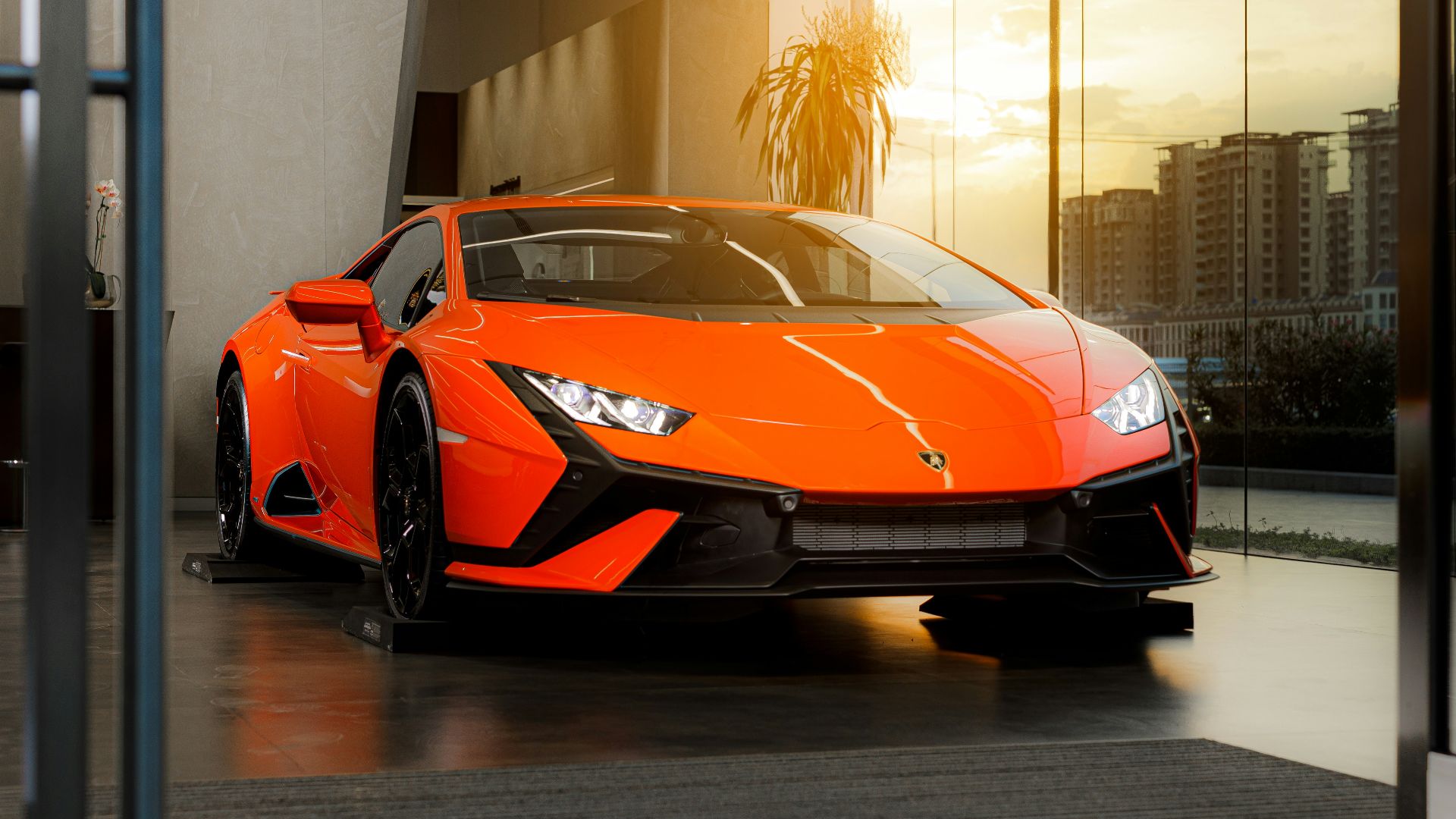 a bright orange sports car parked in front of a building