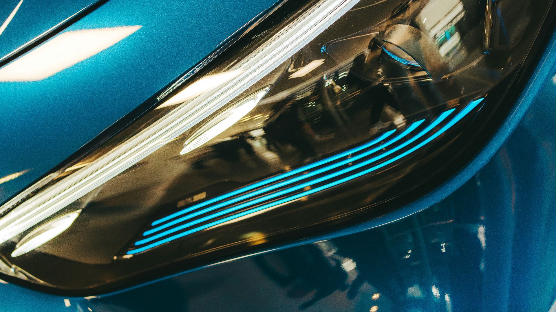 Close-up of a sleek blue car headlight