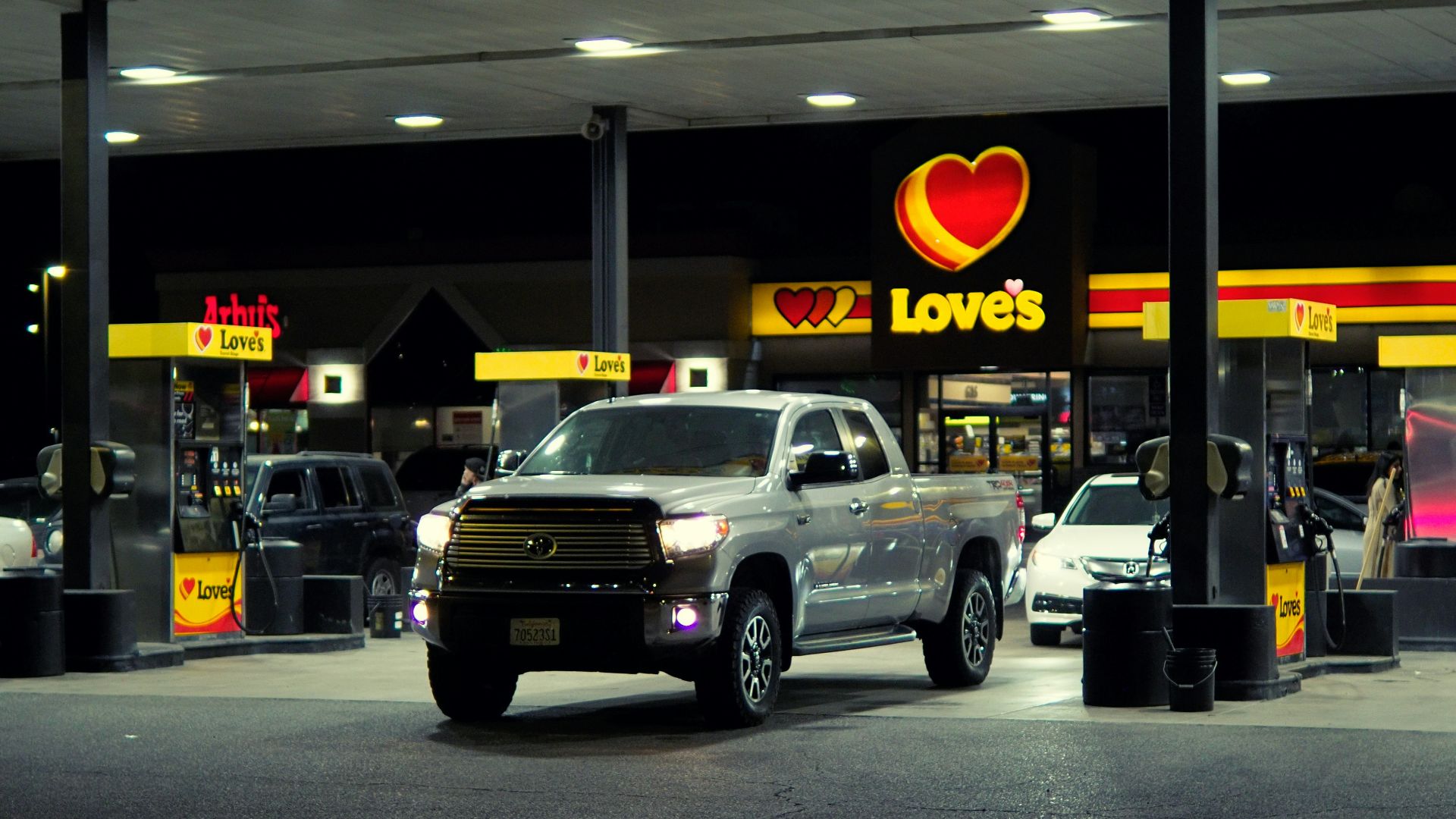 a couple of trucks are parked in front of a love's gas station