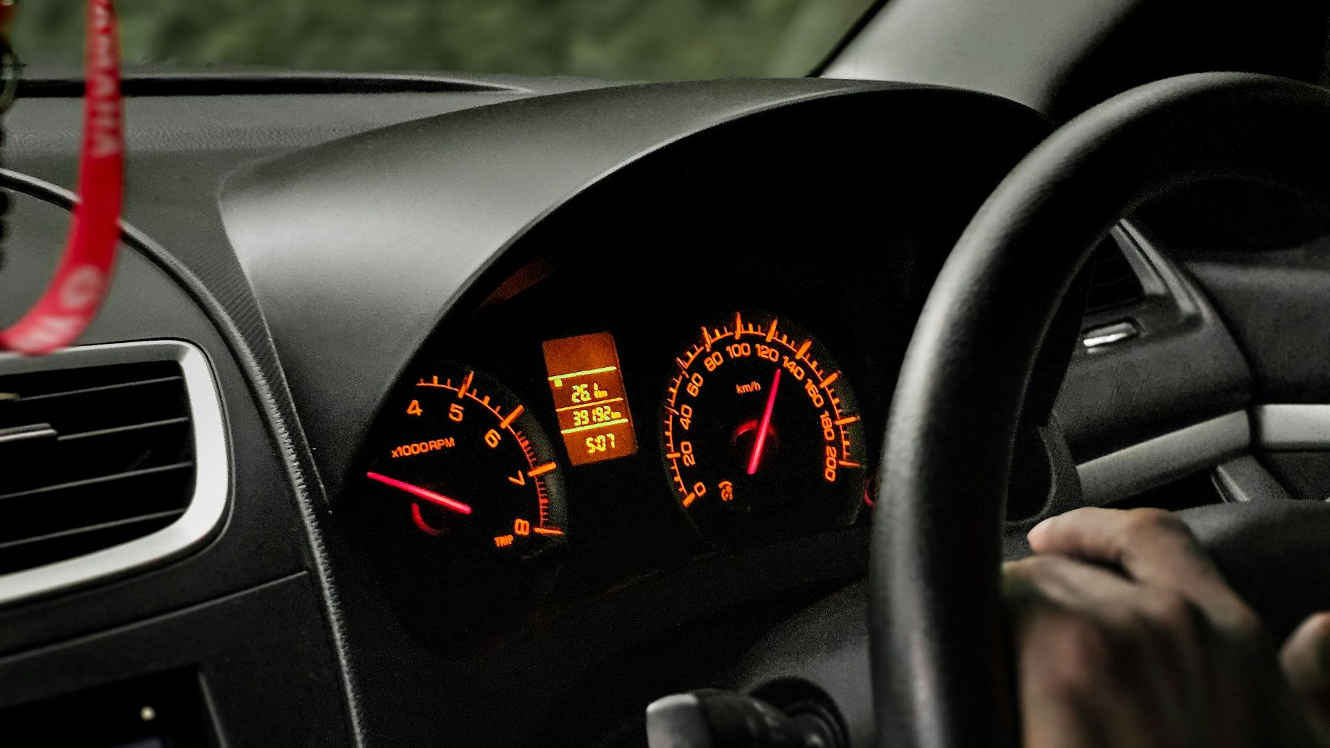 a person driving a car on a road with trees in the background
