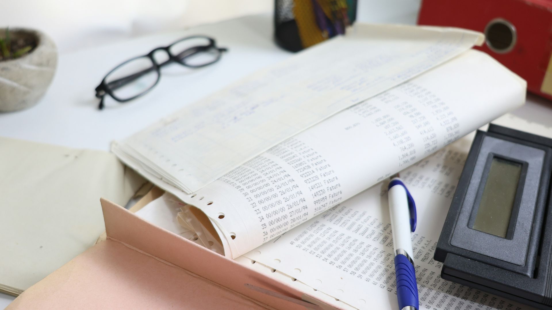 Desk with papers, glasses, calculator, and office supplies