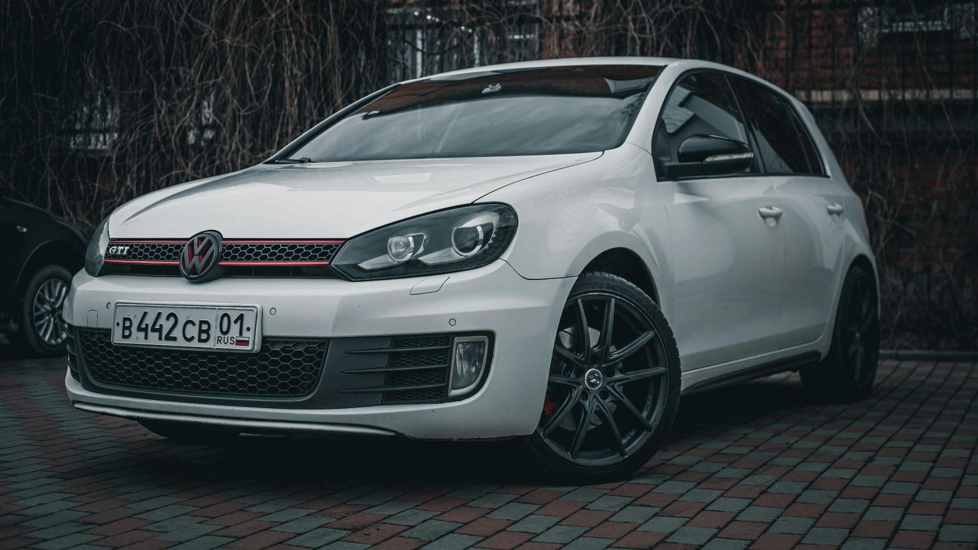 a white car parked in front of a brick building
