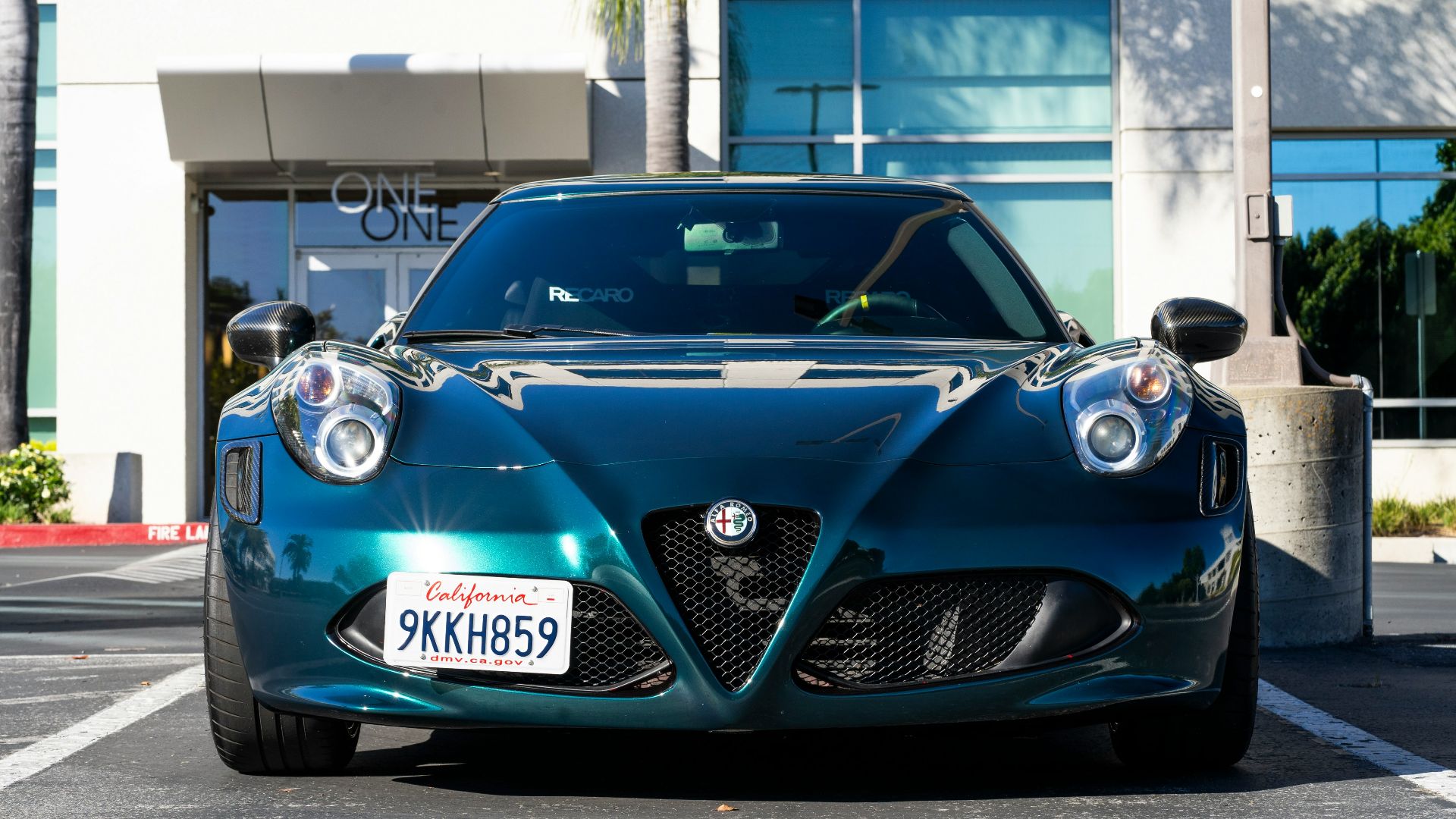 A blue sports car parked in front of a building