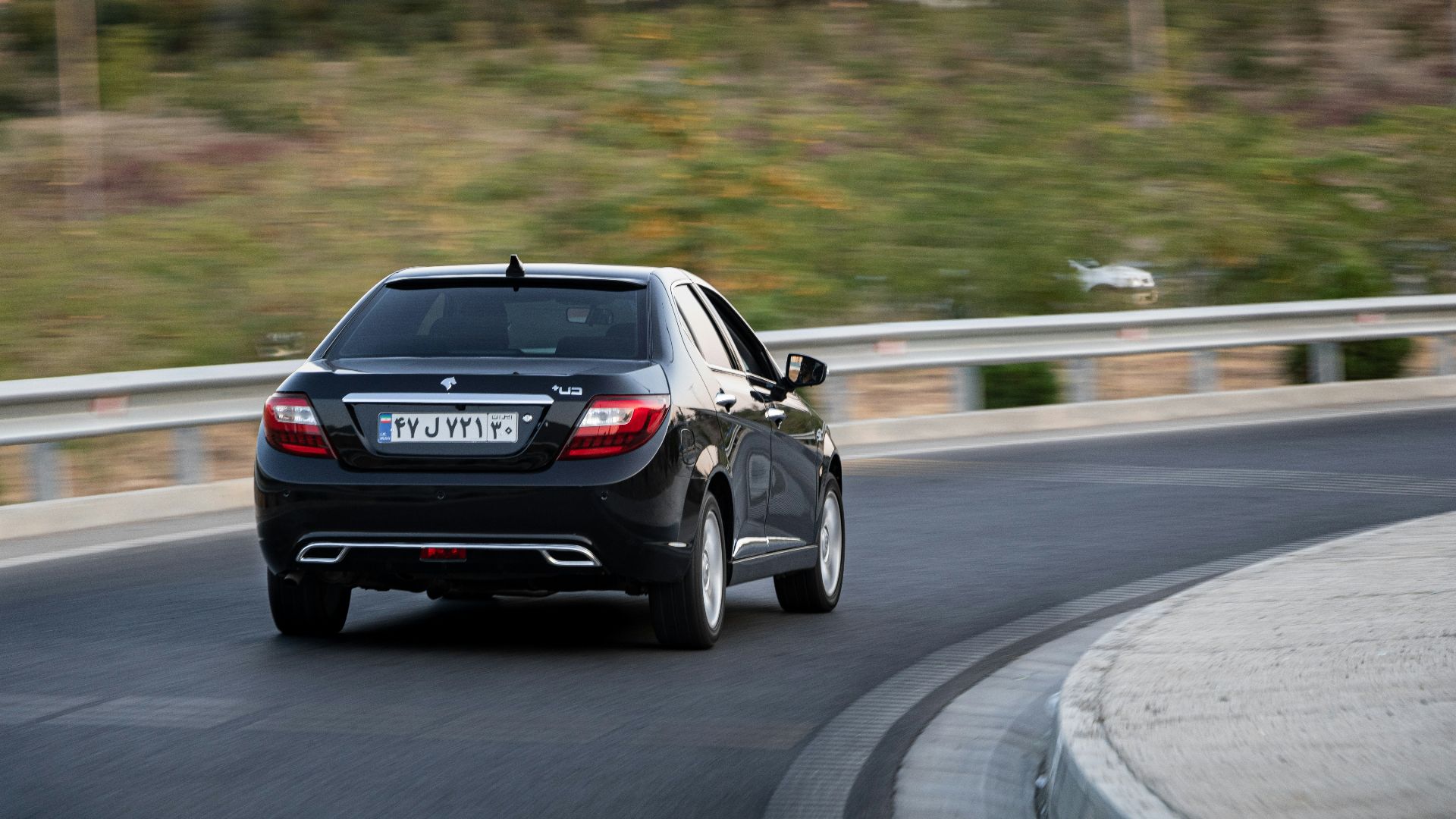a black car driving down a curvy road
