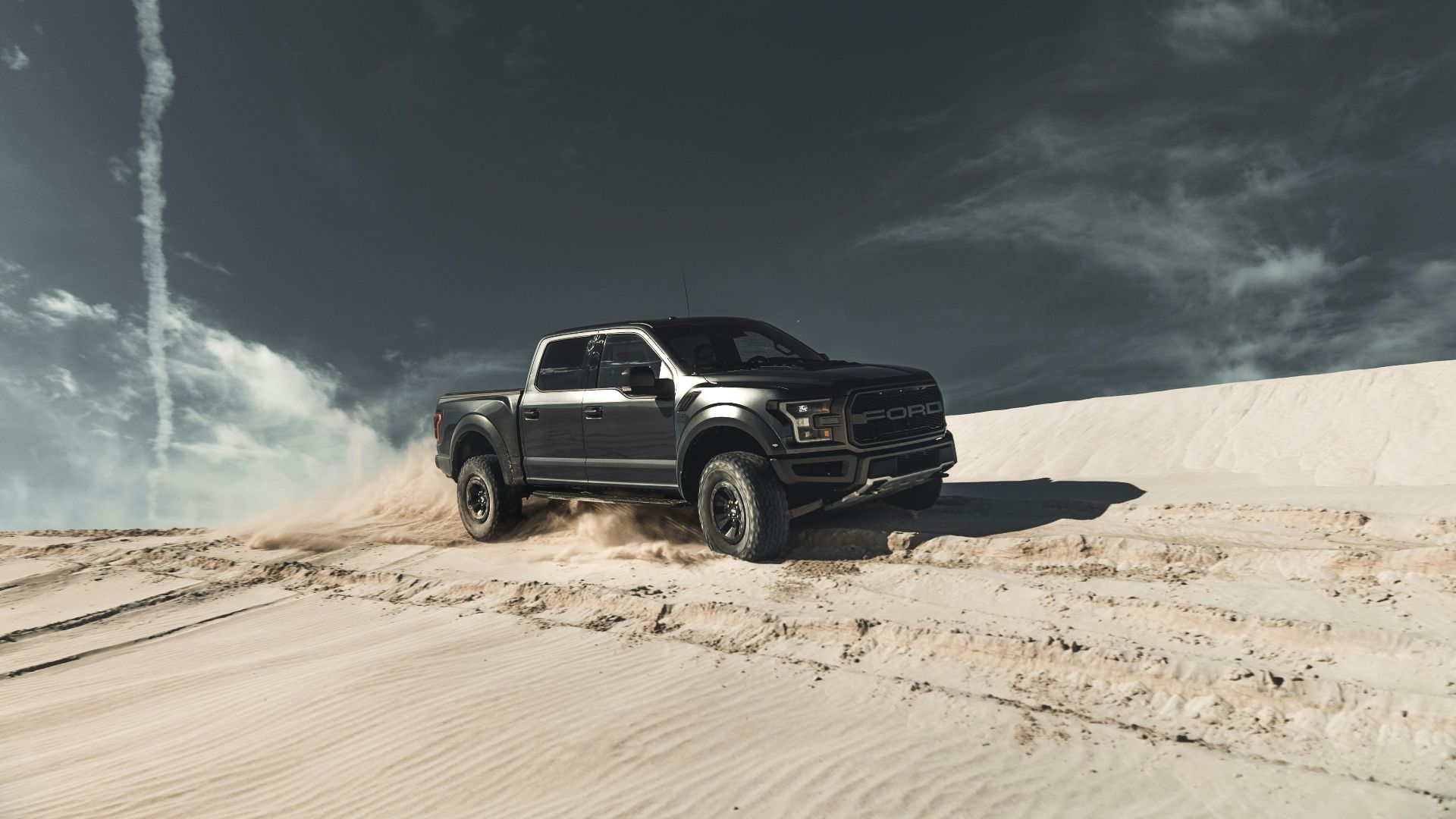 black chevrolet crew cab pickup truck on brown sand under blue sky during daytime