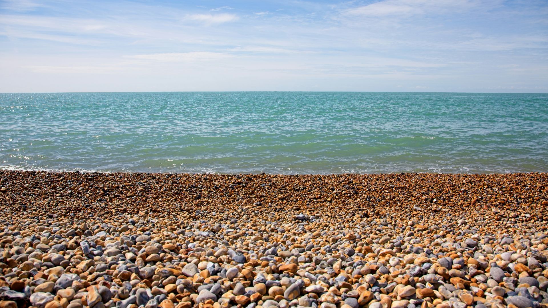 a rocky beach with a body of water in the background