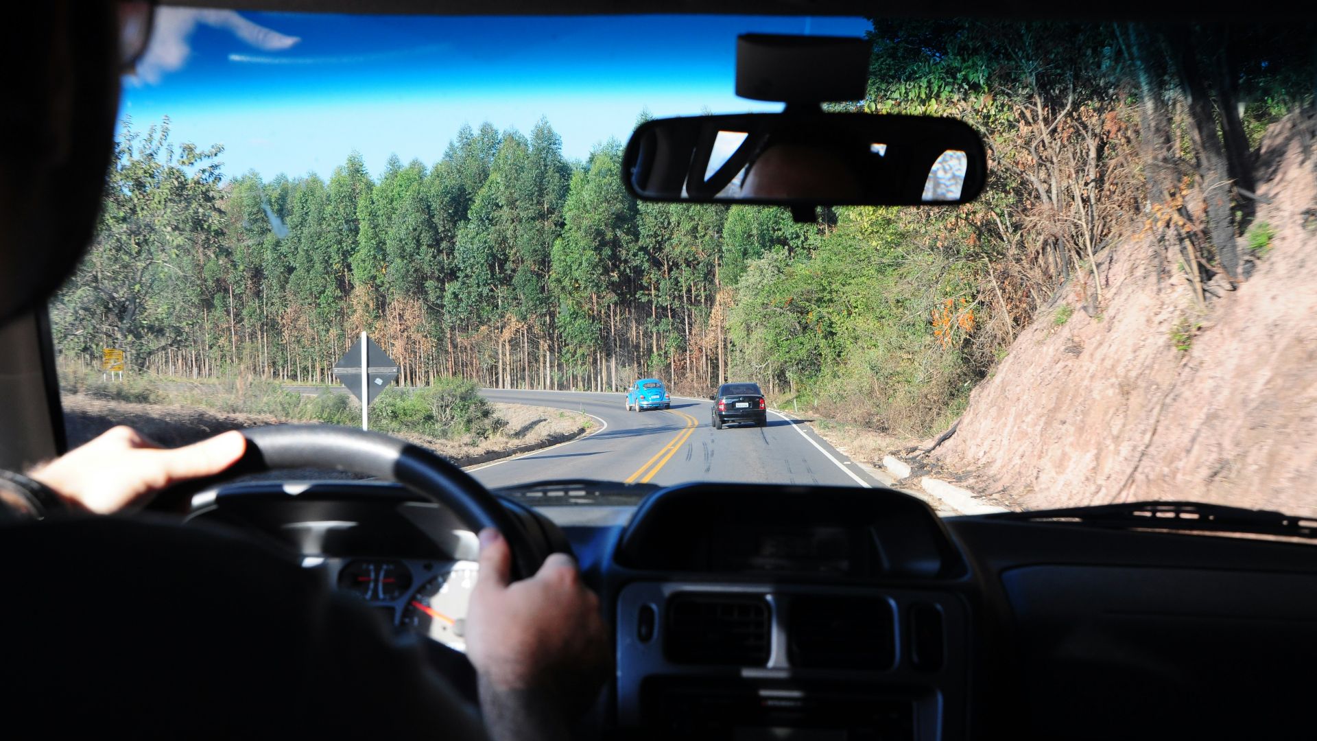 man driving a car on a road