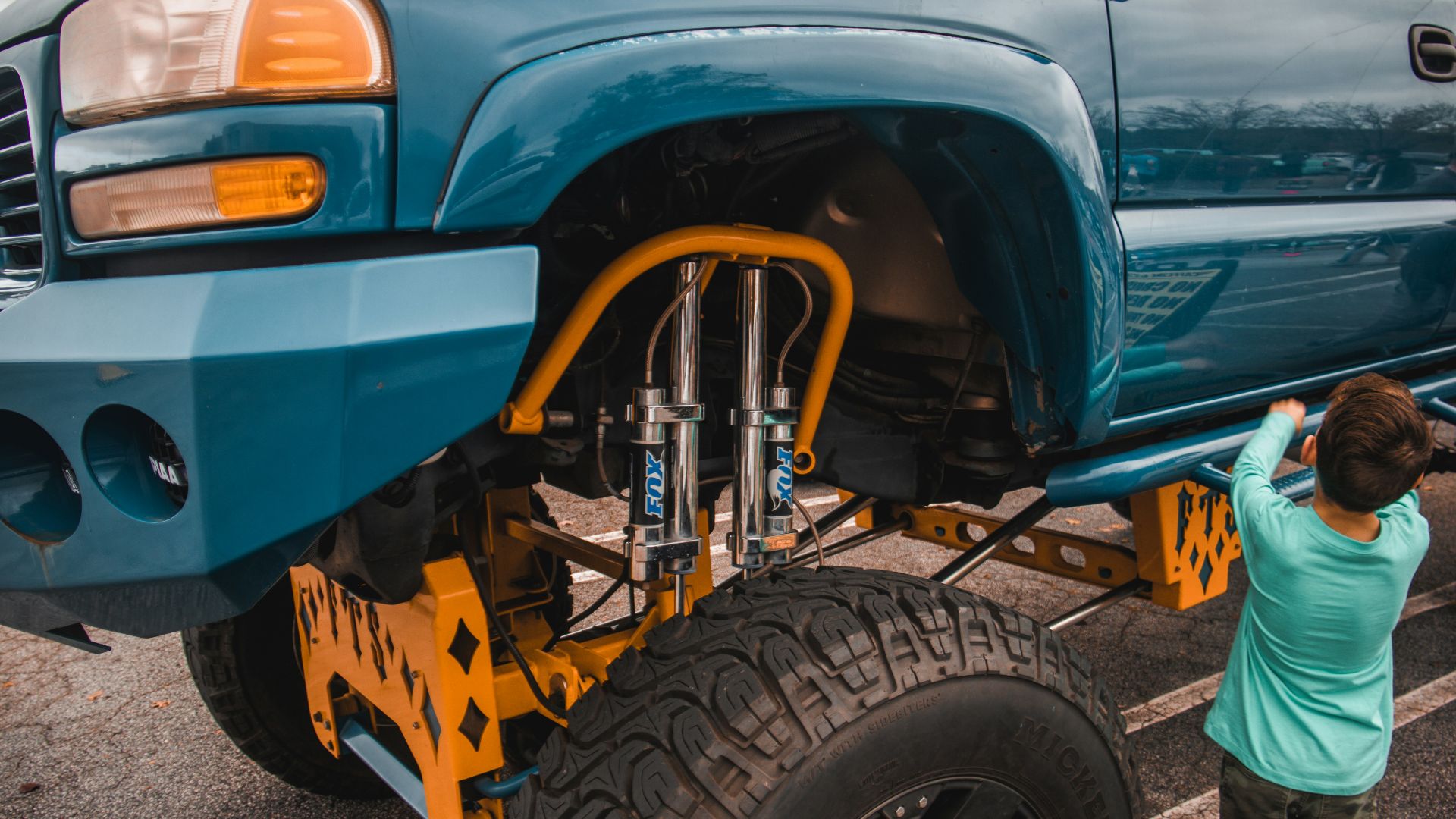 a person standing next to a blue truck