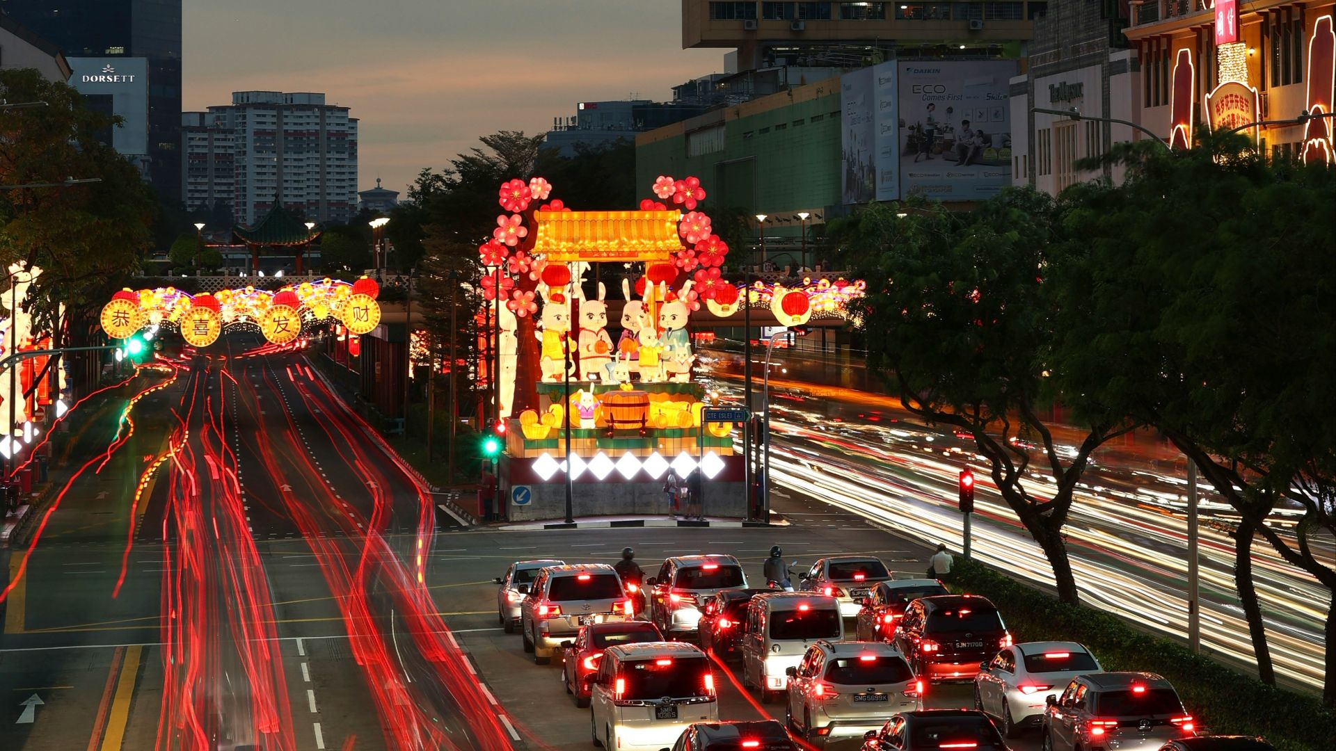 a city street filled with lots of traffic next to tall buildings