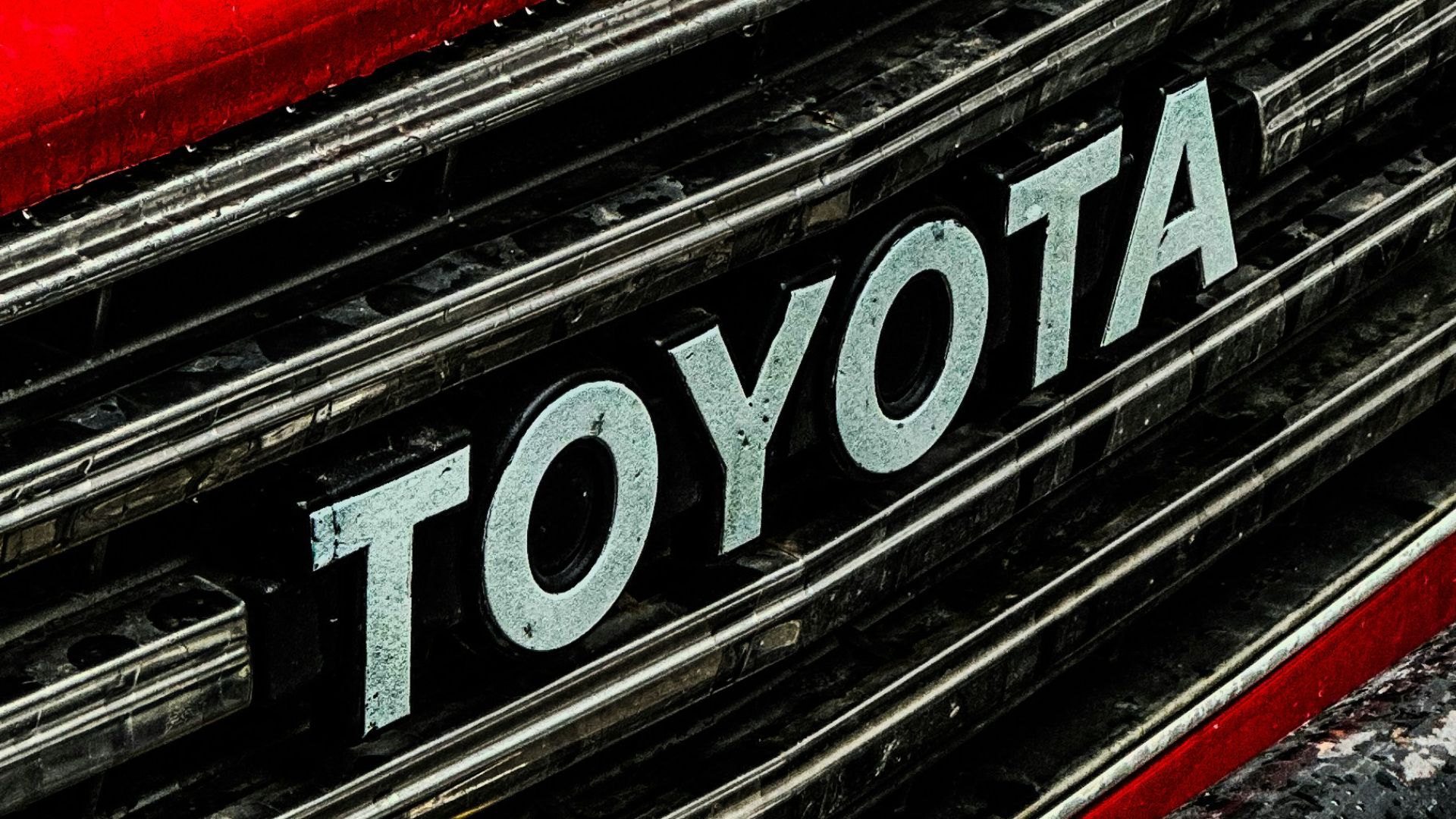 a close up of a toyota logo on a red car