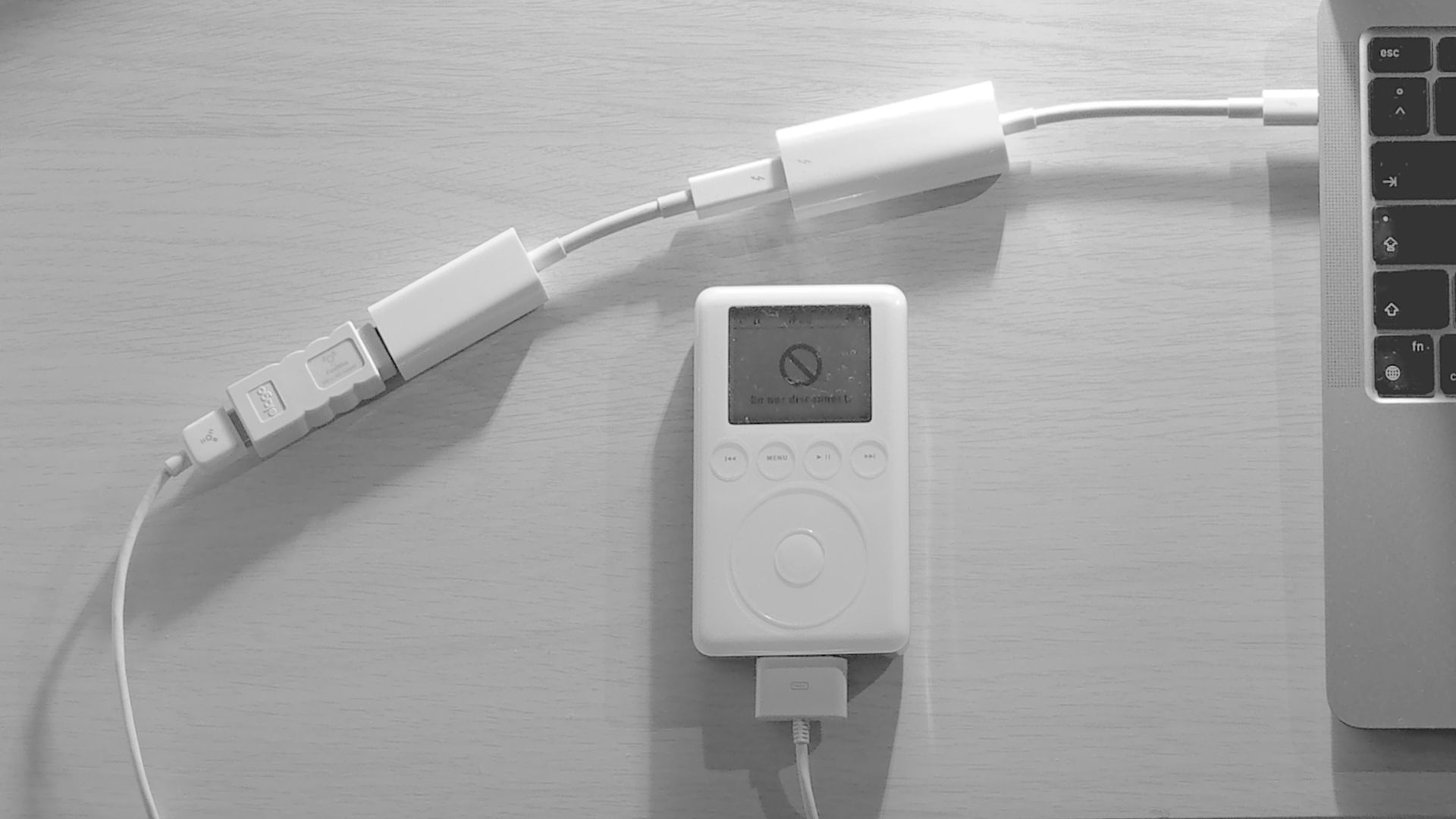 a white corded phone next to a laptop