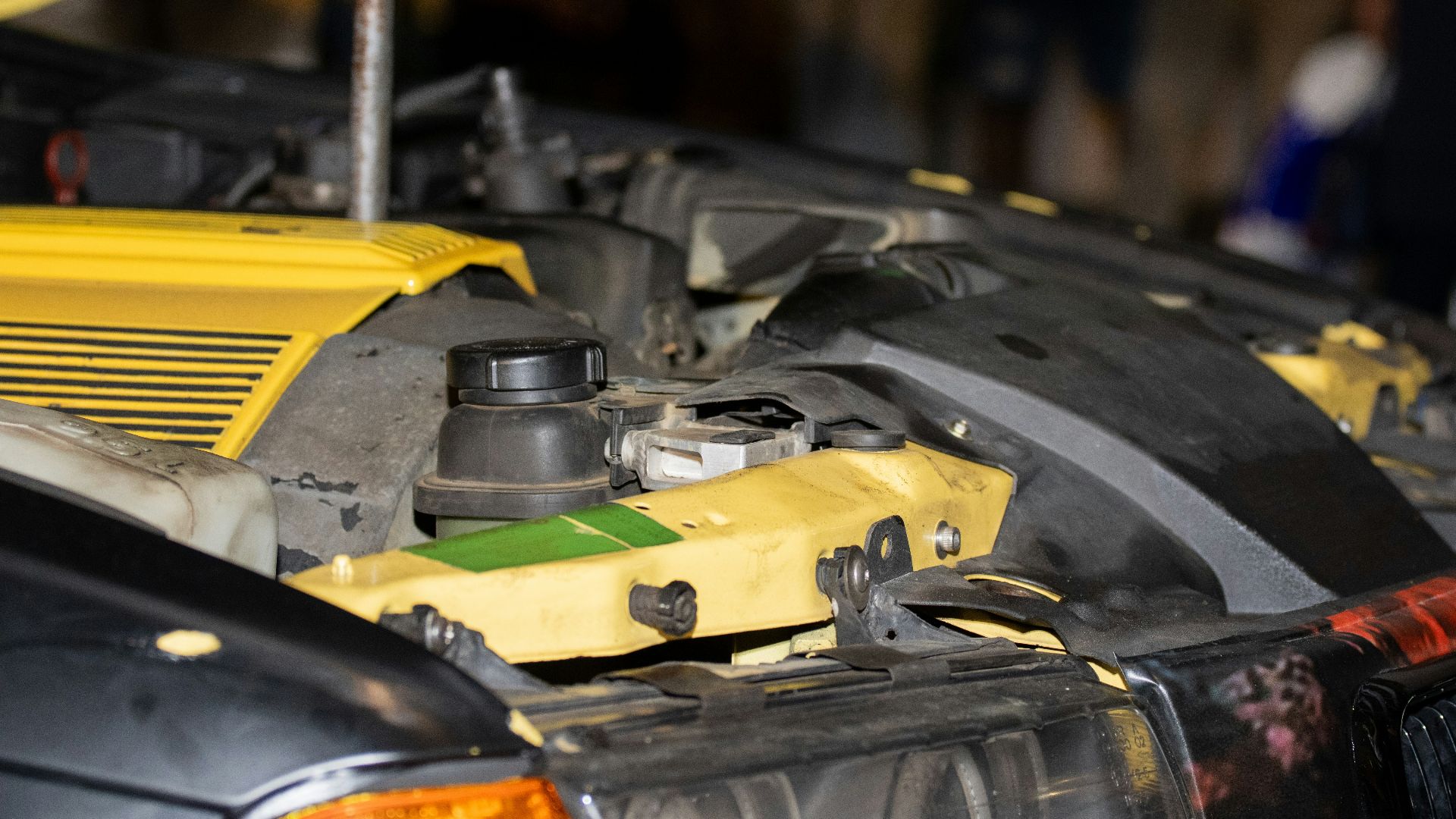 Close-up of a car engine with yellow accents.